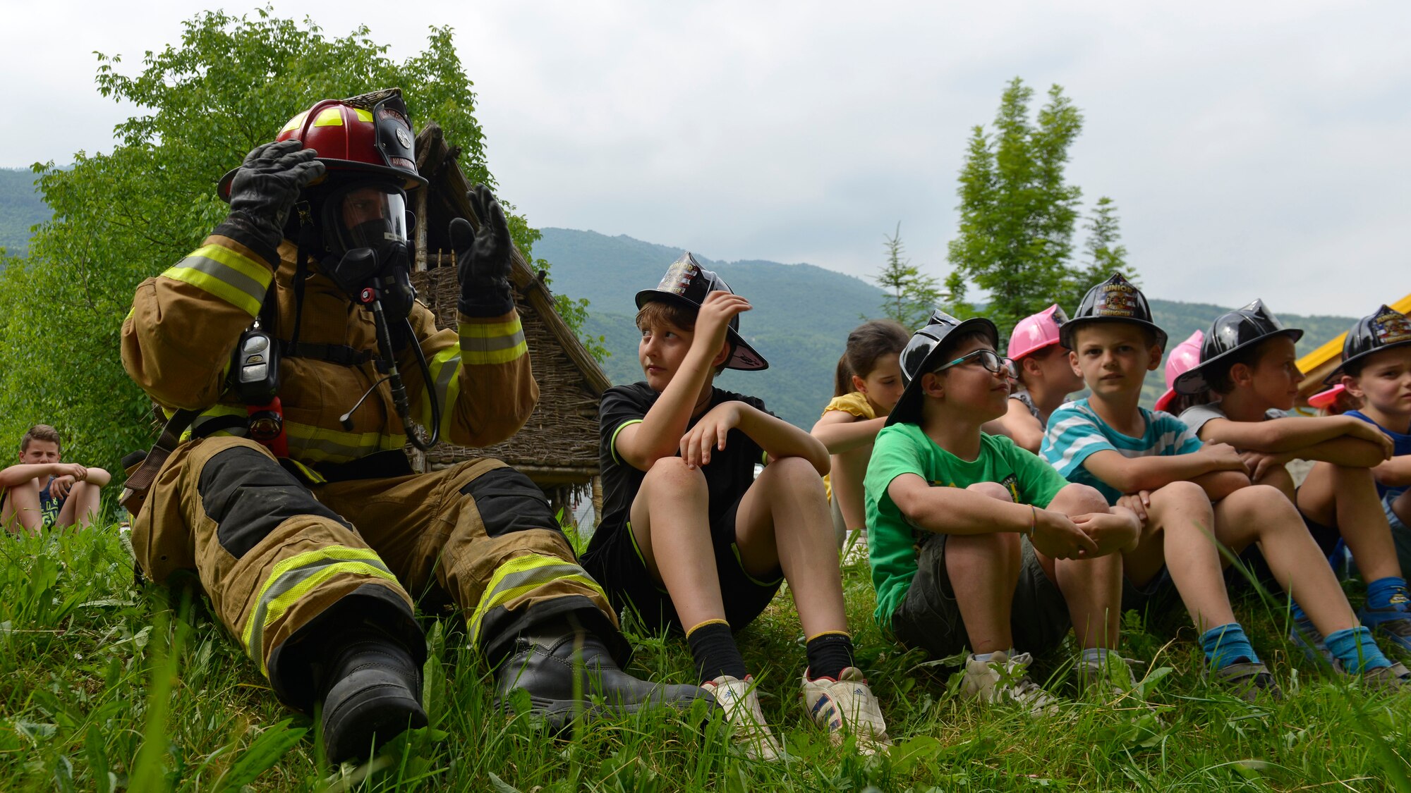 Tech. Sgt. Robert McClanahan, 31st Civil Engineer Squadron lead fire inspector, sits with students of an English after-school program during a fire safety demonstration, May 31, 2017 in Polcinego, Italy. The team brought a fire truck, Sparky the fire dog and several pieces of firefighting equipment. (U.S. Air Force photo by Senior Airman Cary Smith)