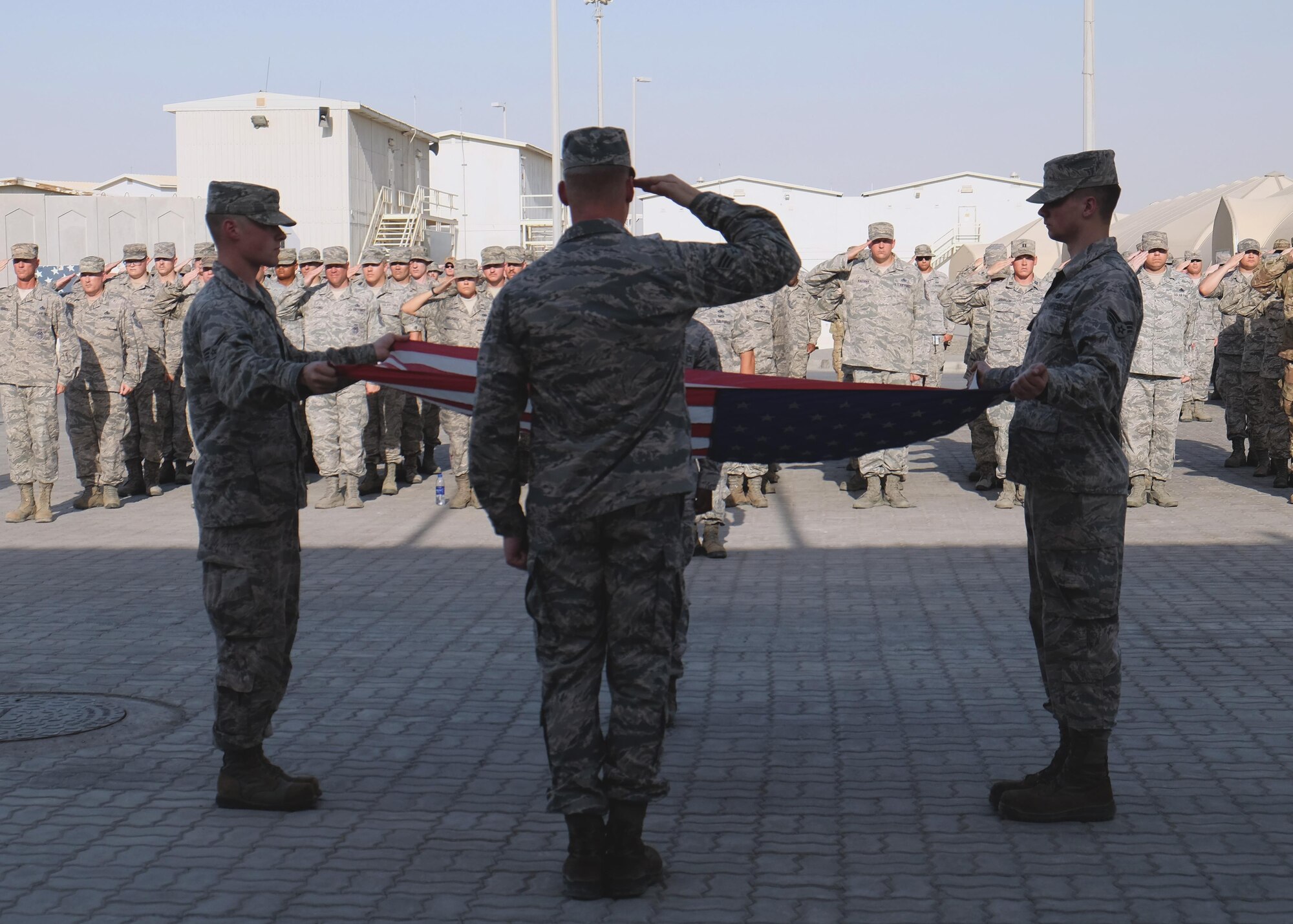 380th Air Expeditionary Wing honor guardsmen prepare to fold the U.S. flag during a monthly retreat ceremony June 2, 2017, at an undisclosed location in southwest Asia. A retreat ceremony, in which the U.S. flag is retired, takes place here on the first Friday of every month. (U.S. Air Force photo by Senior Airman Preston Webb)