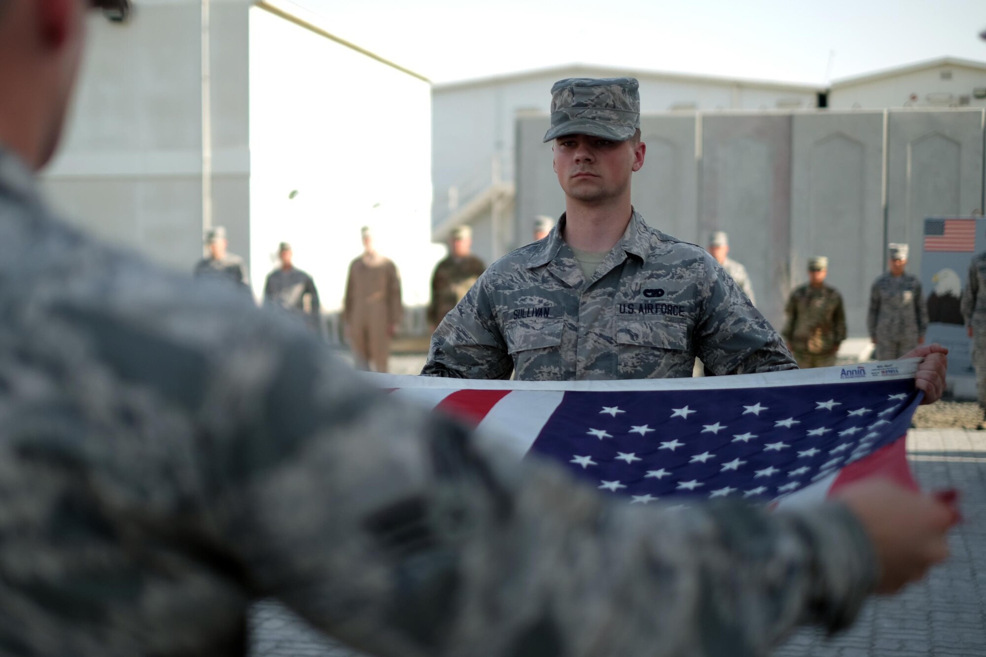380th Air Expeditionary Wing honor guardsmen prepare to fold the U.S. flag during a monthly retreat ceremony June 2, 2017, at an undisclosed location in southwest Asia. A retreat ceremony, in which the U.S. flag is retired, takes place here on the first Friday of every month. (U.S. Air Force photo by Senior Airman Preston Webb)