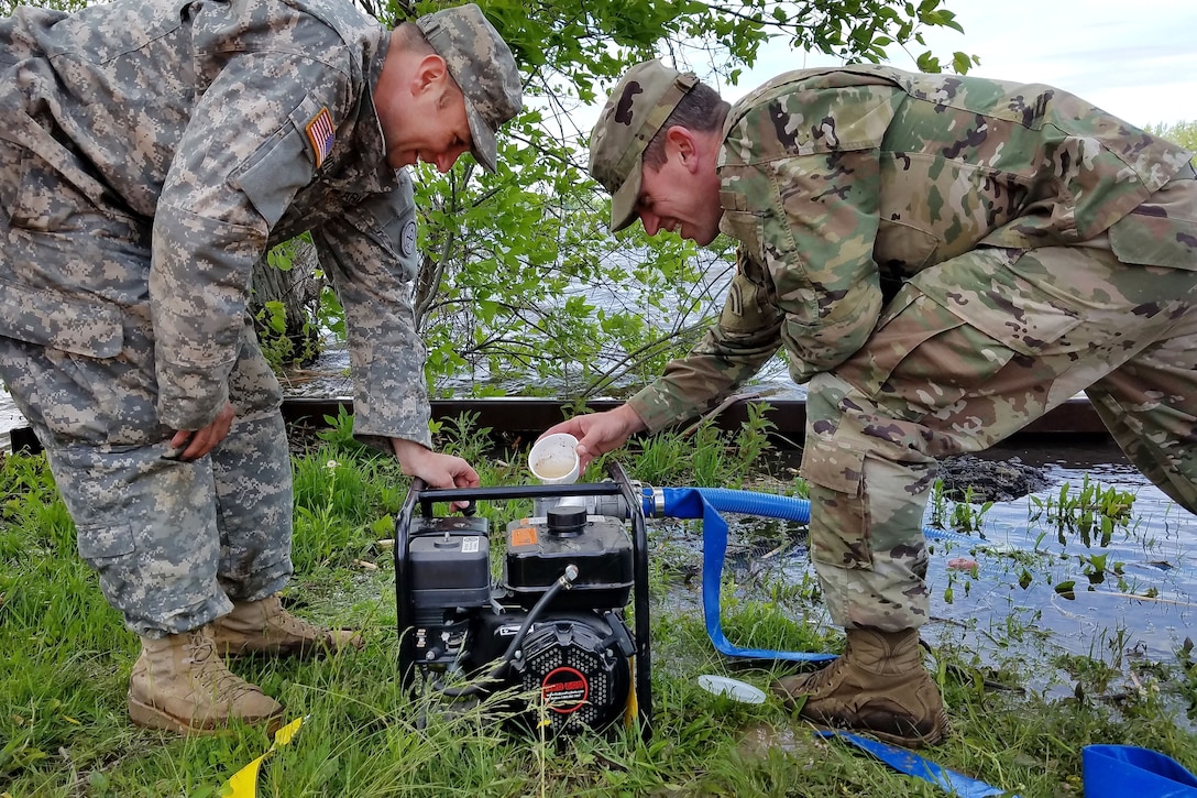 New York Army National Guardsmen prepare to start a power generator to pump water into a Tiger Dam flood control system along the shores of Braddock Bay in Greece, N.Y., June 1, 2017. Army National Guard photo by Sgt. Lucian McCarty