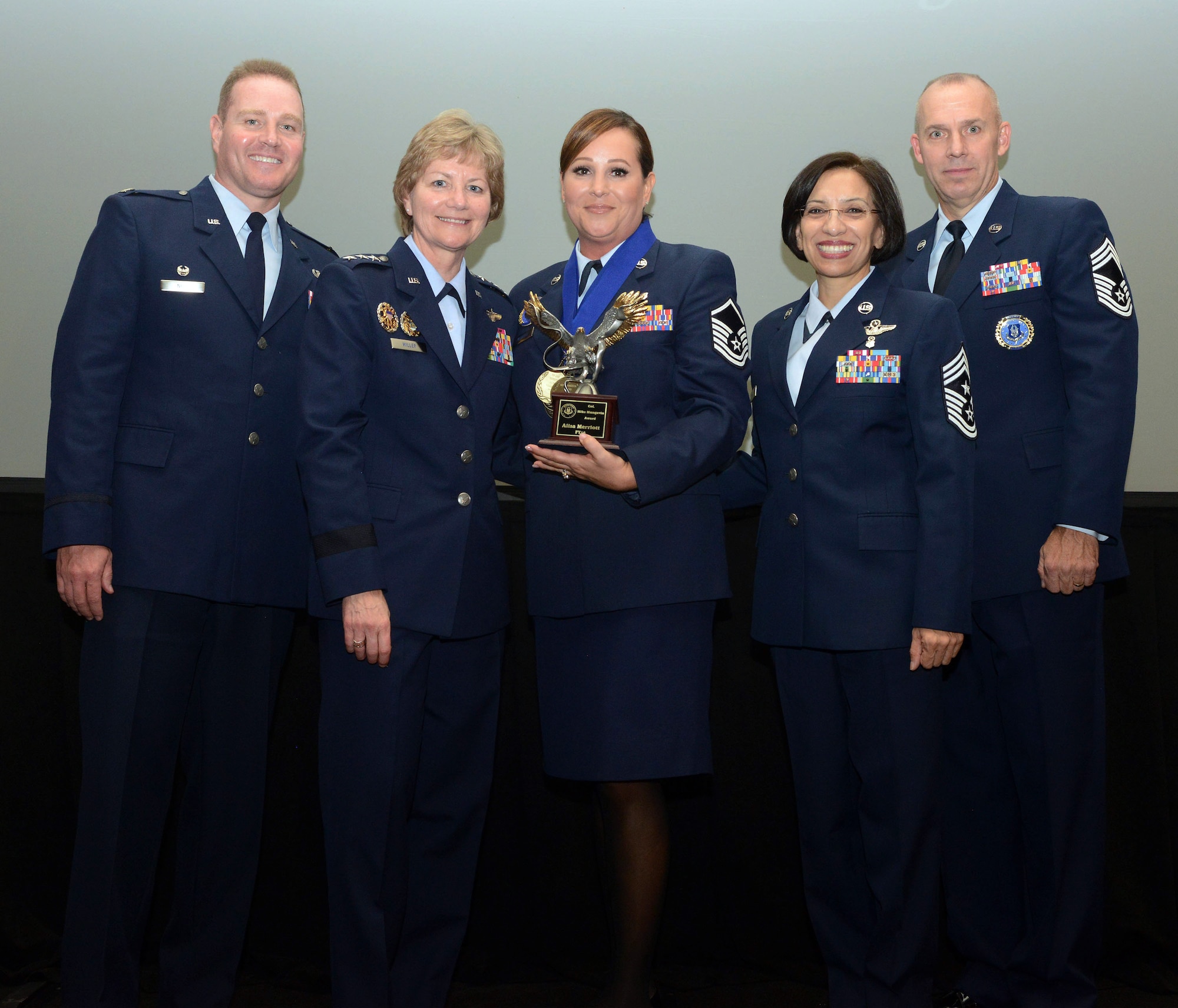Master Sgt. Alisa Merriott (center) poses with the Col. Mike Mungavin Recruiter of the Year Award with (left to right) Col. Chris Nick, former Recruiting Service commander; Lt. Gen. Maryanne Miller, AFRC commander; Chief Master Sgt. Ericka Kelly, AFRC command chief master sergeant; and Chief Master Sgt. Thomas Zwelling, Recruiting Service superintendent.(U.S. Air Force photo by Master Sgt. Chance Babin)