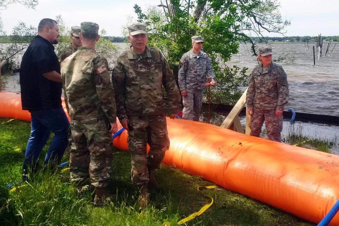 Army Brig. Gen. Raymond F. Shields Jr., center, observes New York Army National Guard soldiers as they deploy the Tiger Dam flood control system along the shores of Braddock Bay in Greece, N.Y., June 1, 2017.  Shields is the commander of the New York Army National Guard and assistant adjutant general of New York. Army National Guard photo by Brig. Gen. Patrick Center