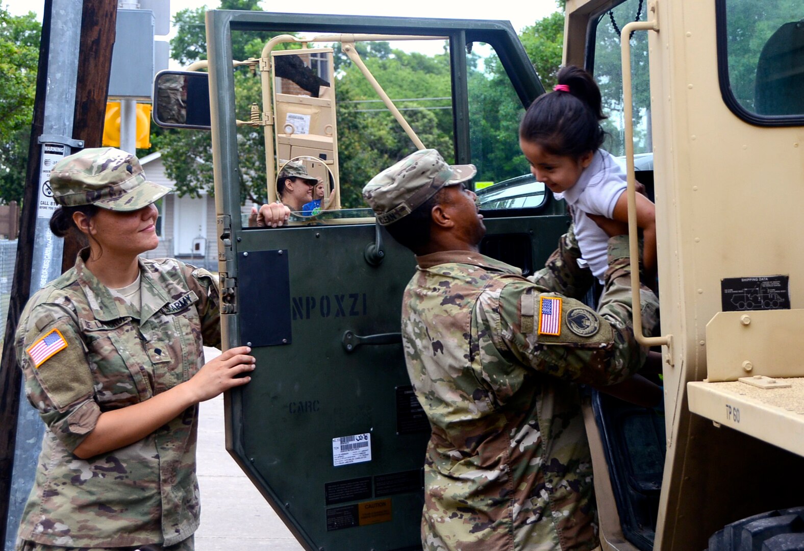 Sgt. Bryant McLean, Headquarters and Headquarters Battalion, U.S. Army South, assists a student into a M1089 wrecker vehicle, during Booker T. Washington Elementary School’s Career Day May 26.  Soldiers allowed the students to sit in the vehicles and honk the horn, to give them an idea of what it is like to be a U.S. Soldier.  The school and unit are partnered through the Adopt-a-School program. 