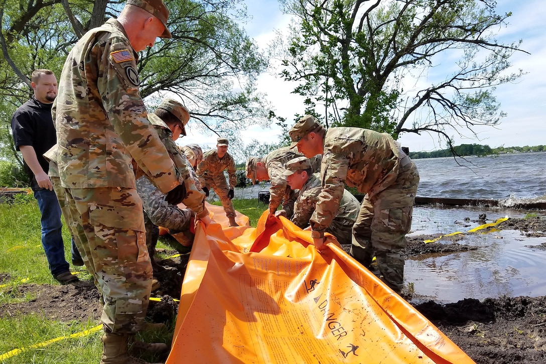 New York Army National Guardsmen prepare to deploy the Tiger Dam flood control system along the shores of Braddock Bay in the Town of Greece, N.Y., June 1, 2017. Army National Guard photo by Sgt. Lucian McCarty 