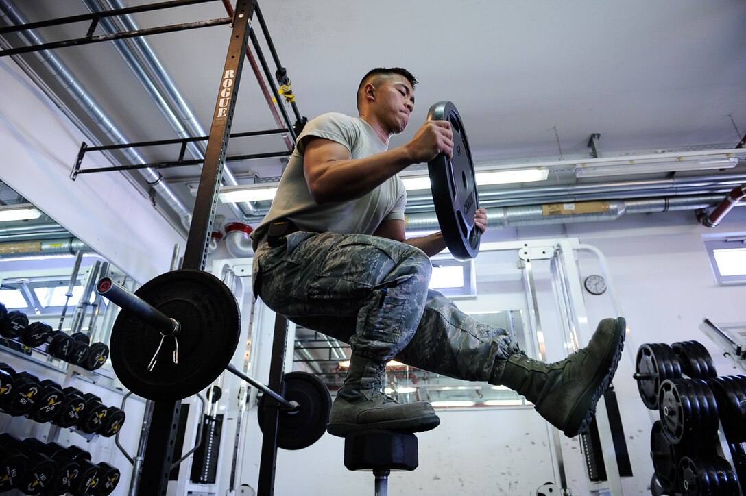 Airman 1st Class Nikko Madarang, 721st Aerial Port Squadron passenger service specialist, balances on one leg and squats during an exercise June 1, 2017, on Ramstein Air Base, Germany. June is Men’s Health Month, and is used to heighten awareness of preventable health problems in men and boys, as well as encourage early treatment of disease. (U.S. Air Force photo by Airman 1st Class Savannah L. Waters)