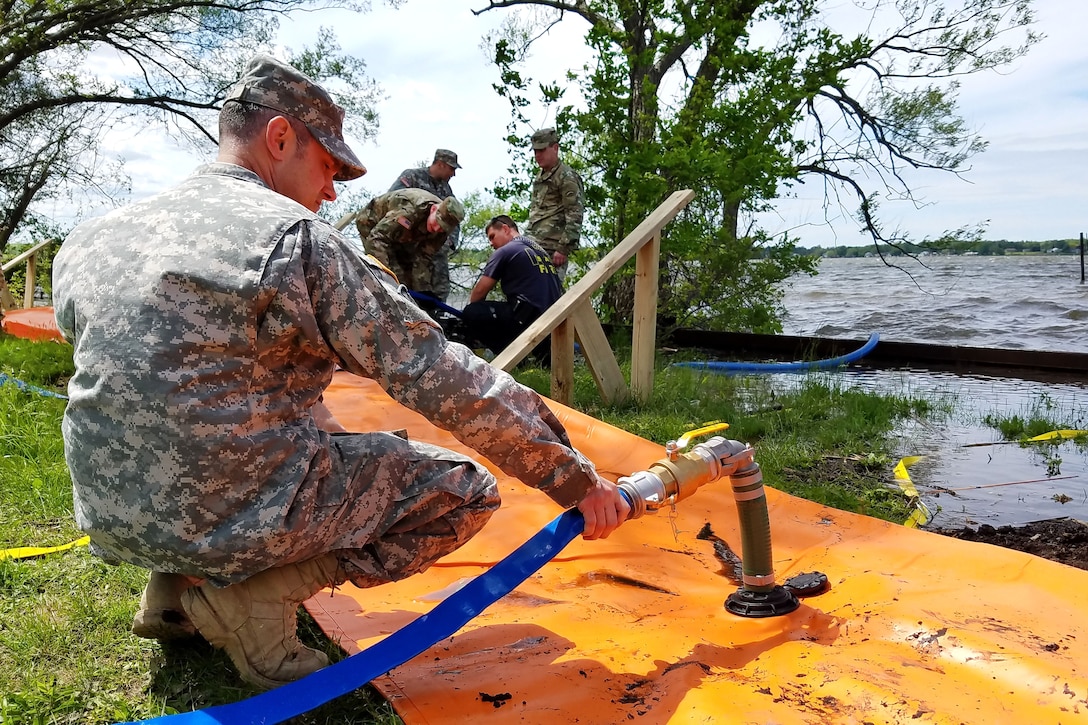 A New York Army National Guardsman adds water to the Tiger Dam flood control system along the shores of Braddock Bay in Greece, N.Y., June 1, 2017. Army National Guard photo by Sgt. Lucian McCarty