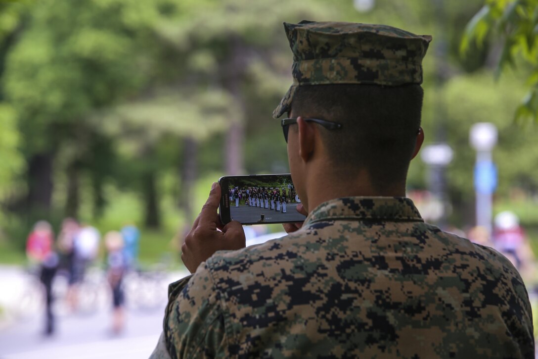 A Marine takes a video of the U.S. Marine Corps Silent Drill Platoon executing precision drill movements during their first performance as part of the New York Fleet Week 2017 tour at Prospect Park in Brooklyn, N.Y., May 27, 2017. Thousands of spectators came to watch the BCD perform during their many performances throughout Fleet Week New York 2017. (Official U.S. Marine Corps photo by Lance Cpl. Damon Mclean/Released)