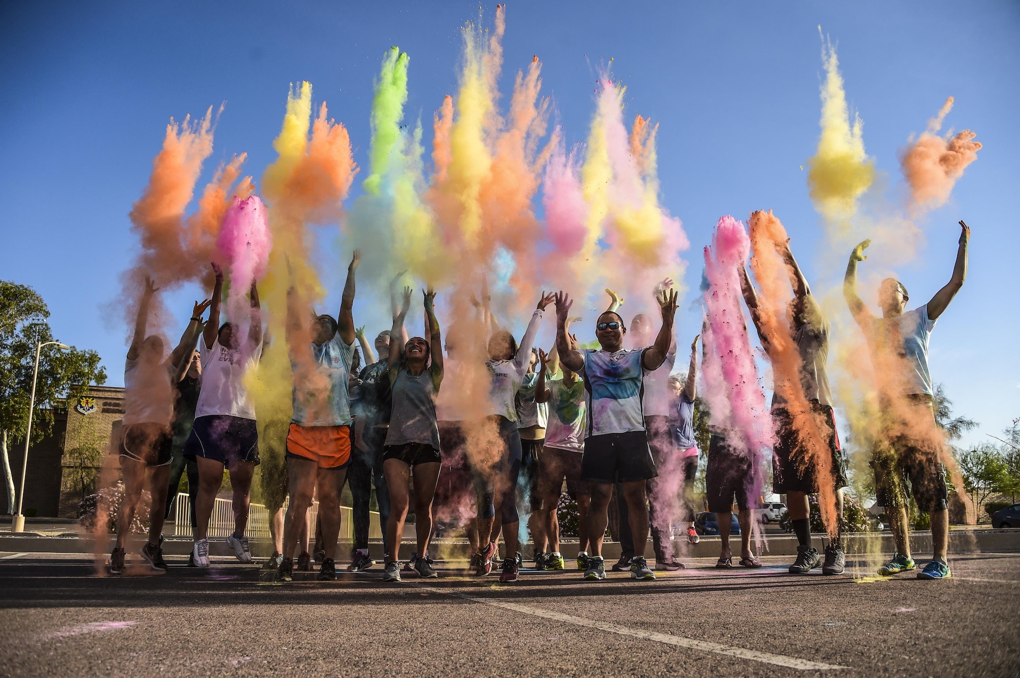 Volunteers and participants of the LGBT Pride Month 5k color run throw colored chalk into the air as a celebration for completing the run June 1, 2017 at Luke Air Force Base, Ariz. In 2009, President Barack Obama issued the month of June as Lesbian, Gay, Bisexual and Transgender Pride Month. Since then, military installations around the globe have participated in events celebrating the diversity of the LGBT community. (U.S. Air Force photo by Airman 1st Class Caleb Worpel)