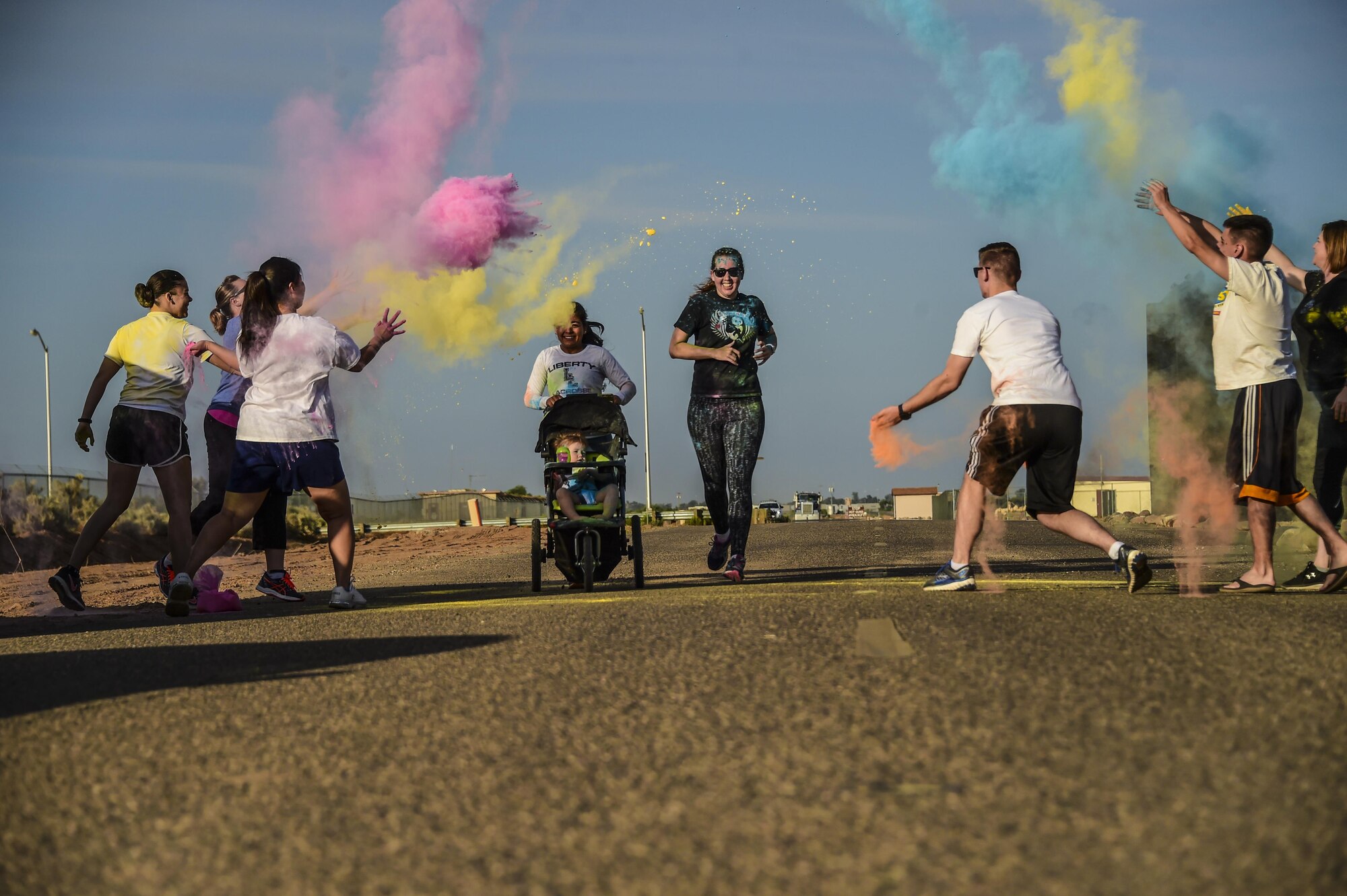 Runners participating in the LGBT Pride Month 5k color run pass through a colored powder throwing station June 1, 2017 at Luke Air Force Base, Ariz. The multicolored chalk was a representation of the LGBT community rainbow flag. (U.S. Air Force photo by Airman 1st Class Caleb Worpel)