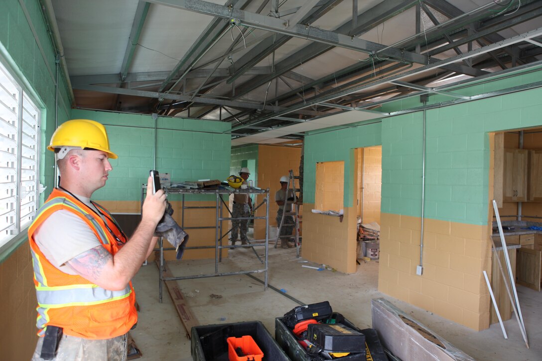 US Army Sgt. Matthew Dillion, a site safety officer with the 409th Engineer Company, 244th Engineer Battalion, monitors the installation of a drop ceiling and takes photos of its progress May 27, 2017 at the construction site of a new medical in Ladyville, Belize. The 409th is helping build the new health clinic as a part of Beyond the Horizon 2017, a U.S. Southern Command-sponsored, Army South-led exercise designed to provide humanitarian and engineering services to communities in need, demonstrating U.S. support for Belize. (U.S. Army photo by Sgt. 1ST Class Marvin Daniels) (RELEASED)