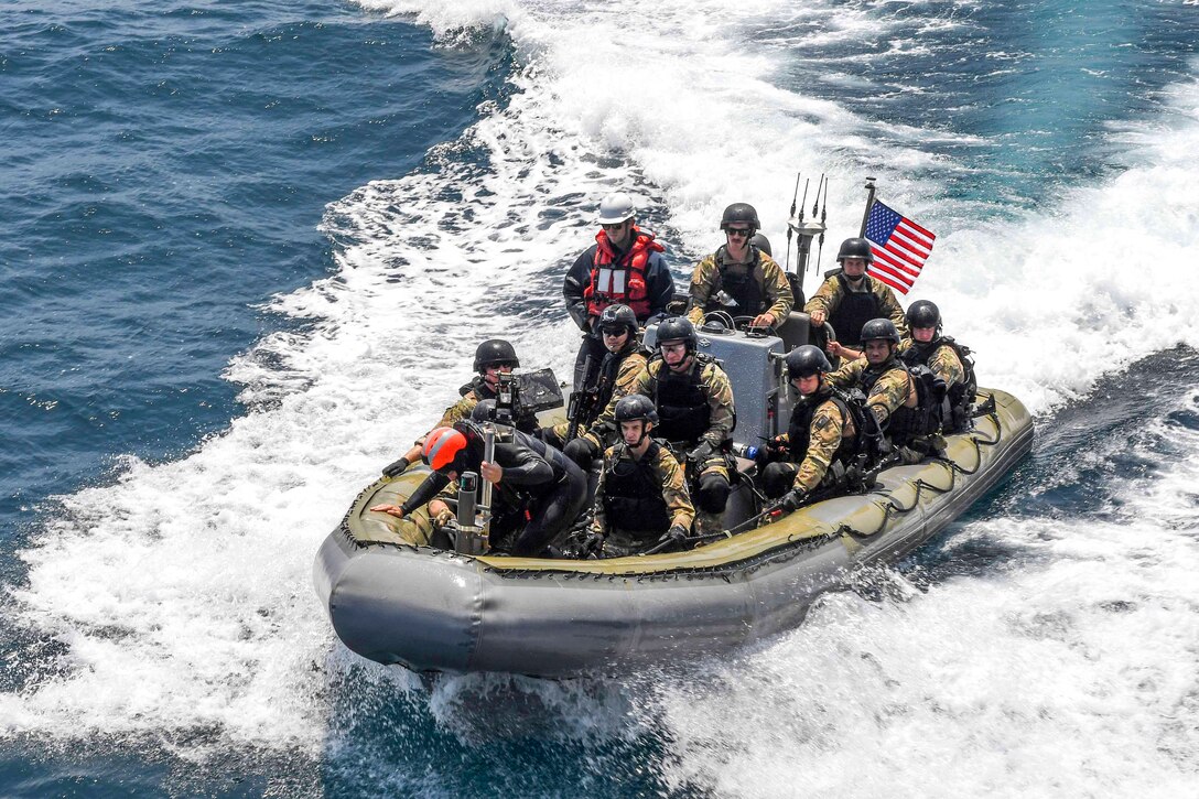 U.S. sailors ride in a rigid-hull inflatable boat as they approach the USS Wayne E. Meyer during visit, board, search and seizure training  in the western Pacific Ocean, May 22, 2017. Navy photo by Petty Officer 3rd Class Kelsey L. Adams
