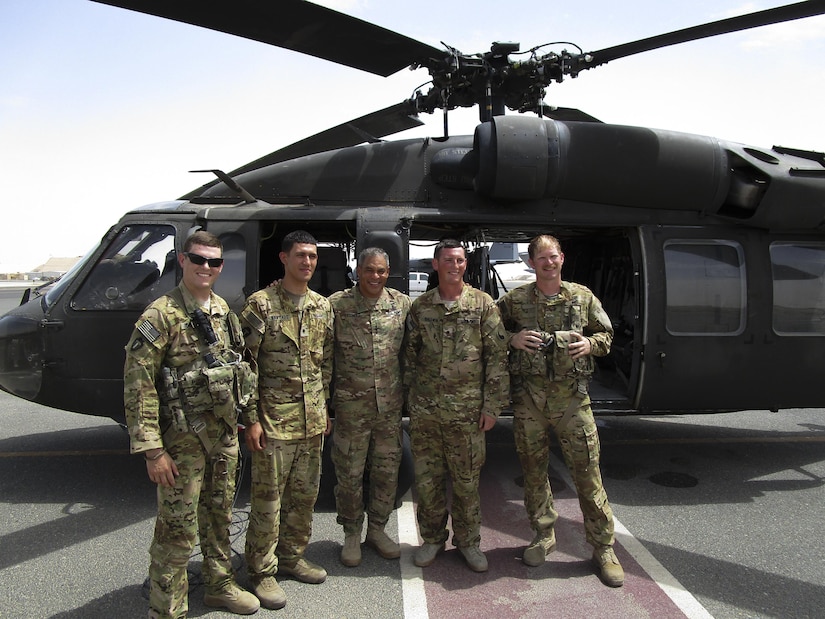 Lt. Gen. Michael Garrett, the commanding general of U.S. Army Central, stands with (left) 1st Lt. Benjamin Gonzales, (direct left of Garrett) Spc. Jesus Santiago, (direct right of Garrett) Spc. Benjamin Baldwin, and (right) Chief Warrant Officer 2 Richard Minton, a UH-60 Blackhawk helicopter crew, for A Company, 2nd General Support Aviation Battalion, 149th Aviation Regiment, after an impromptu combat patch ceremony on the helicopter landing pad at Ali Al Salem Air Base, May 20. Gonzalez organized the surprise combat patch ceremony for the new crew chiefs. (U.S. Army photo by Lt. Col. Derek Johnson, USARCENT)