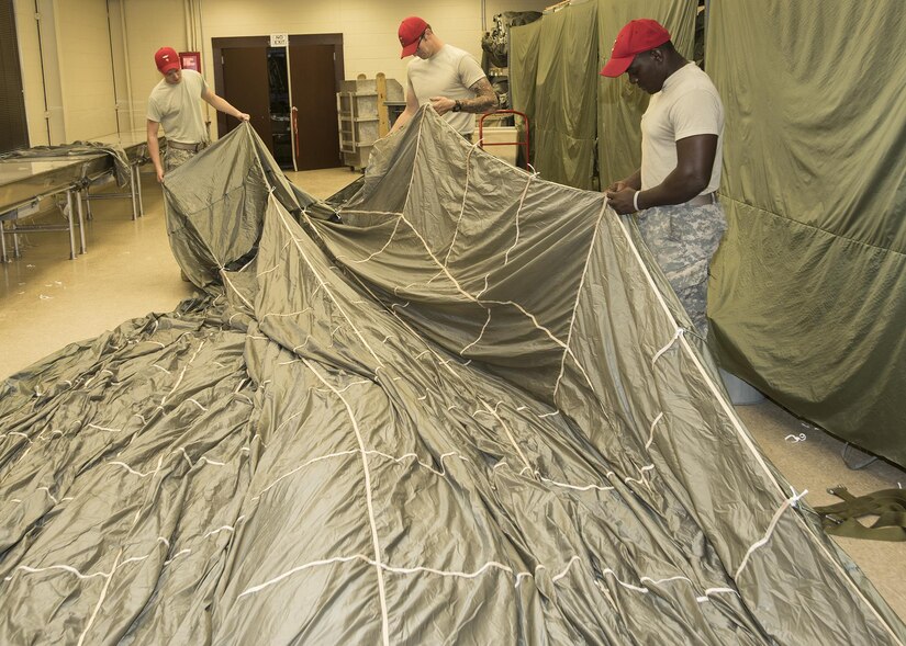 Parachute riggers (Spc. Dillan J. Halstead (left), Spc. A.J. Thomas (center), and Spc. Chester R. Bannis (right), all with the Nashville, Tennessee-based Army Reserve 861st Quartermaster Company, contribute to Army readiness and equipment modernization while taking part in an operational test of the Advanced Low Velocity Airdrop System - Light/Heavy (ALVADS-L/H) with the Fort Hood, Texas-based U.S. Army Operational Test Command's Airborne and Special Operations Test Directorate (ABNSOTD) at Fort Bragg, North Carolina. ALVADS-L/H allows air drops of supplies from altitudes lower than ever before. (Photo Credit: U.S. Army file photo)
