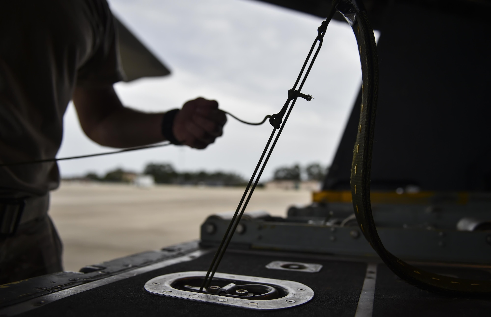 Tech. Sgt. Zach Kelhi, a loadmaster with the 15th Special Operations Squadron, ties down a heavy equipment extract parachute line to an MC-130H Combat Talon II at Hurlburt Field, Fla., May 30, 2017. After an extract parachute is deployed, the wind force pulls cargo off the ramp of aircraft. (U.S. Air Force photo by Airman 1st Class Joseph Pick)