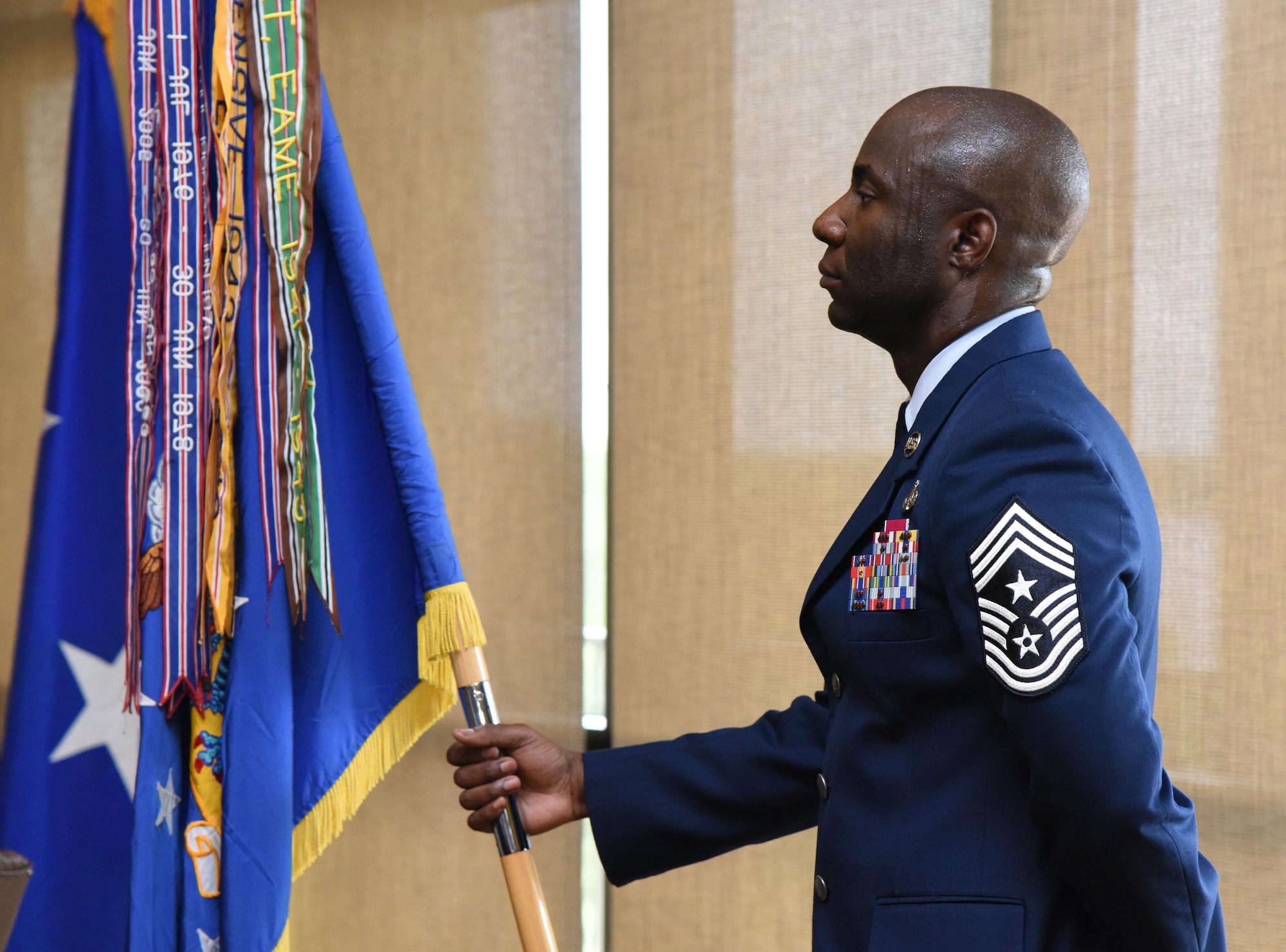 Chief Master Sgt. Vegas Clark, 81st Training Wing command chief, holds the guidon during a change of command ceremony at the Bay Breeze Event Center June 2, 2017, on Keesler Air Force Base, Miss. The ceremony is a symbol of command being exchanged from one commander to the next by the handing-off of a ceremonial guidon. Col. Debra Lovette took command of the 81st TRW from Col. Michele Edmondson. (U.S. Air Force photo by Kemberly Groue)