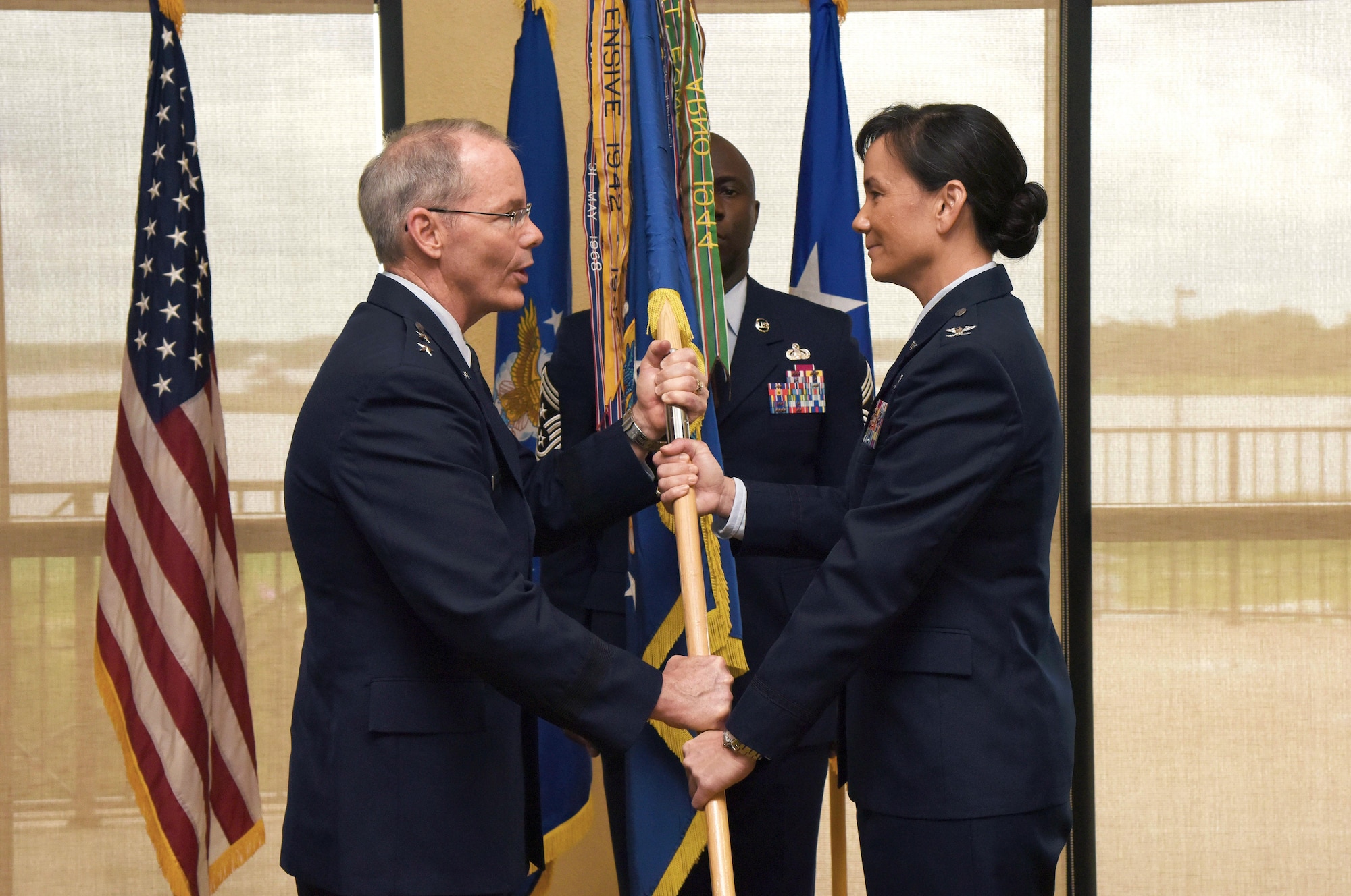 Maj. Gen. Bob LaBrutta, 2nd Air Force commander, passes the guidon to Col. Debra Lovette, 81st Training Wing commander, during a change of command ceremony at the Bay Breeze Event Center June 2, 2017, on Keesler Air Force Base, Miss. The ceremony is a symbol of command being exchanged from one commander to the next. Lovette assumed command of the 81st TRW from Col. Michele Edmondson. (U.S. Air Force photo by Kemberly Groue)