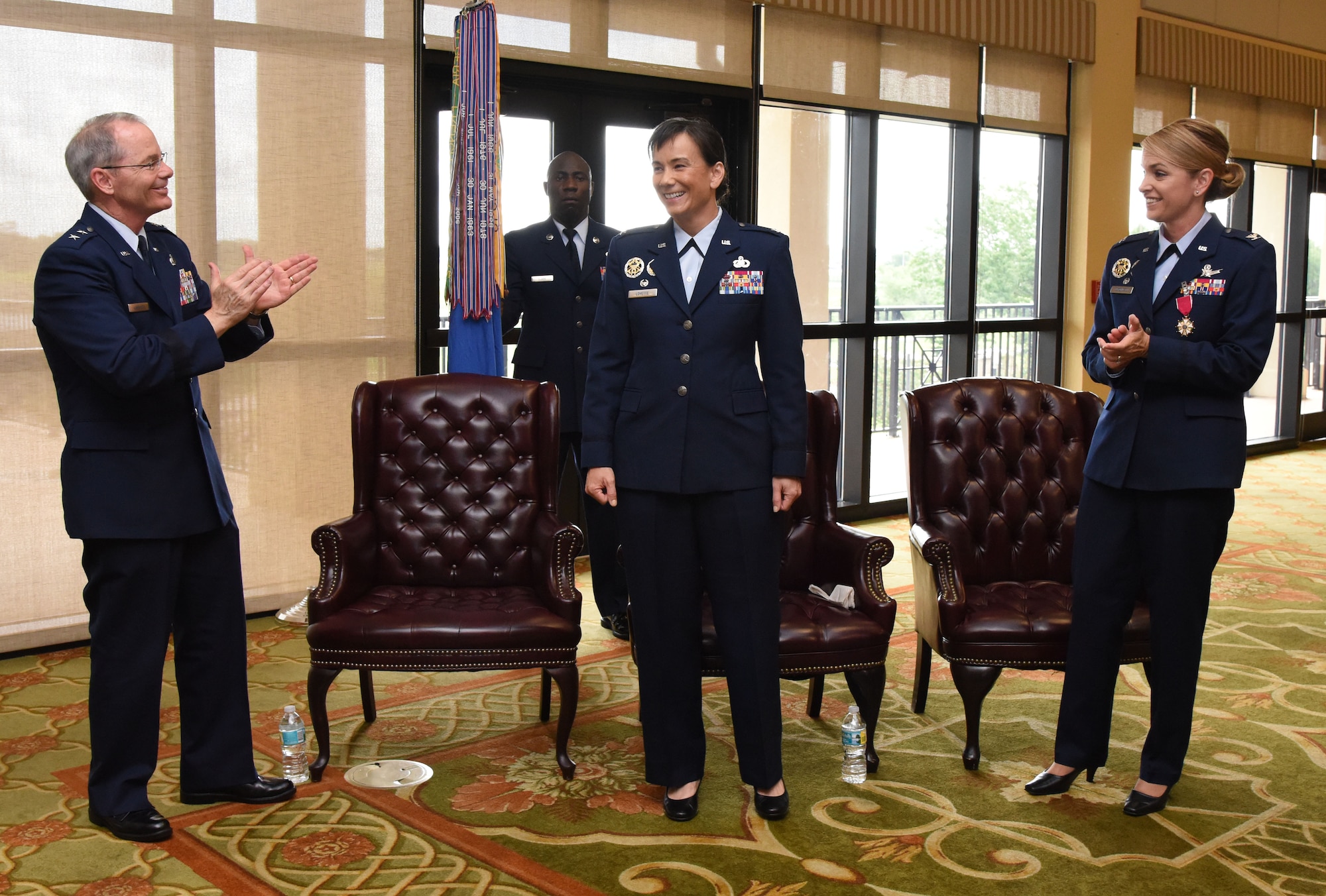 Maj. Gen. Bob LaBrutta, 2nd Air Force commander, and Col. Michele Edmondson, outgoing 81st Training Wing commander, applaud for Col. Debra Lovette, 81st TRW commander, as she assumed command during a change of command ceremony at the Bay Breeze Event Center June 2, 2017, on Keesler Air Force Base, Miss. The ceremony is a symbol of command being exchanged from one commander to the next by the handing-off of a ceremonial guidon. (U.S. Air Force photo by Kemberly Groue)