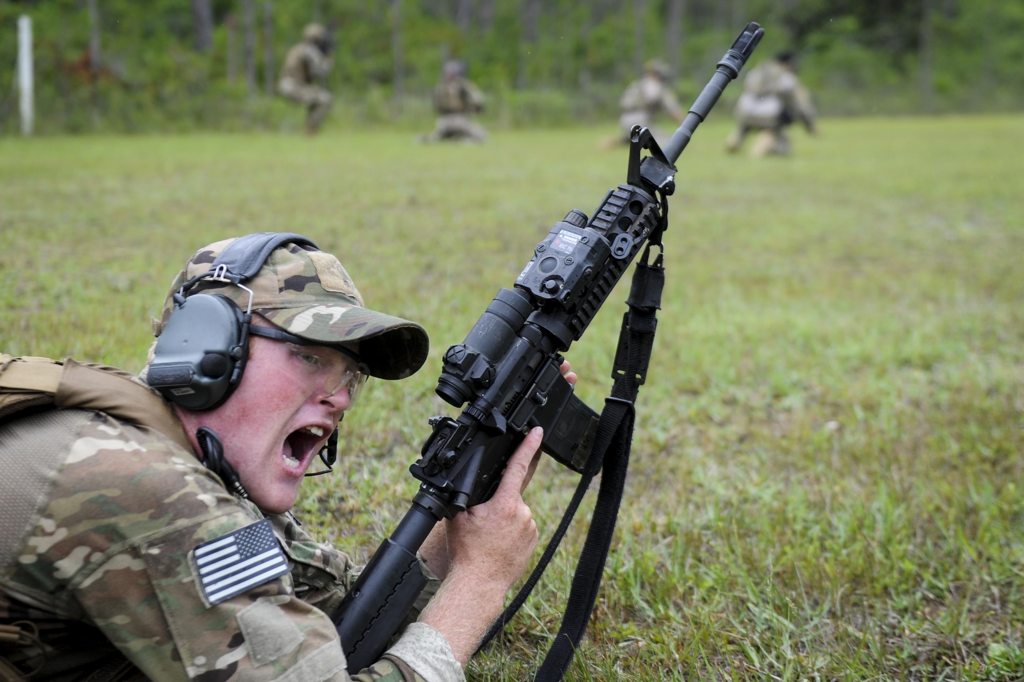 Senior Airman Ethan Pierce, a Deployed Aircraft Ground Response Element member with the 1st Special Operations Security Forces Squadron, commands his team to move during a shoot, move, communicate drill at Hurlburt Field, Fla., June 1, 2017. Shoot, move, communicate is an exercise used to train Defenders to give suppressive fire – fire that hinders an enemy from completing their mission – while under fire, avoid freezing up while in a gun fight, and continue communication with team mates.. (U.S. Air Force photo by Airman 1st Class Dennis Spain)