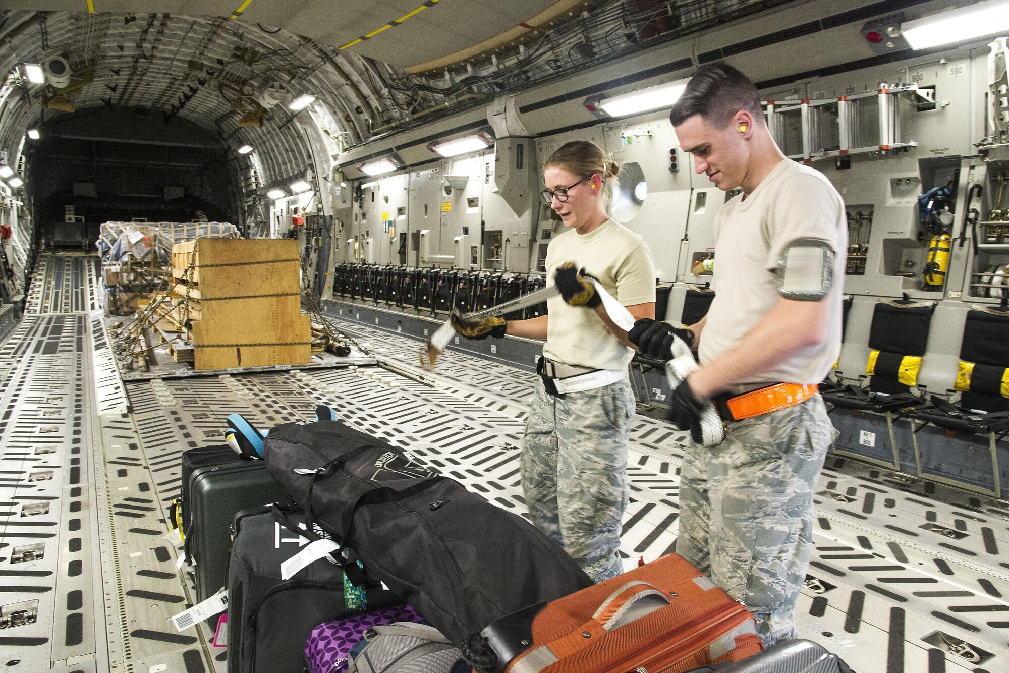 U.S. Air Force Staff Sgt. Jessica Gwinn, of Dover, Del., a Reserve Citizen Airmen with the 48th Aerial Port Squadron, and Airmen 1st Class Charles Workman, of Pittsburg, Pa., a member of the 735th Air Mobility Squadron, secure luggage aboard a C-17 Globemaster III for an outgoing Space Available flight at Joint Base Pearl Harbor-Hickam, Hawaii, March 11, 2017. Members of the 48th Aerial Port Squadron support the Space A Travel program during their two-week annual training and monthly unit training assembly. Located on Oahu and a component of the Air Force Reserve, the 48th Aerial Port Squadron provides expertise in all areas of air terminal operations to include aircraft loading, cargo processing and inspecting, passenger services, aircraft fleet services and aerial port command and control. (U.S. Air Force photo by Master Sgt. Theanne K. Herrmann)