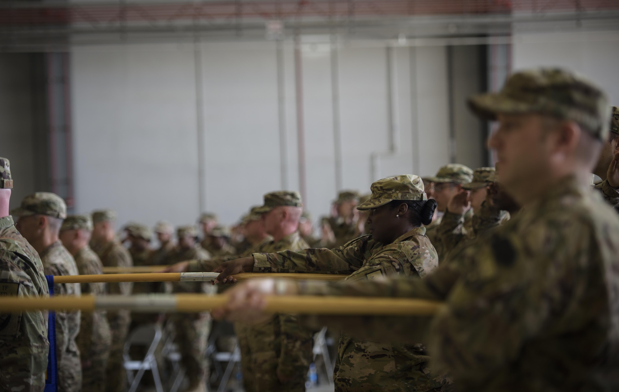 Airmen from the 455th Air Expeditionary Wing lower their group guidons as the national anthem is sung during a change of command ceremony at Bagram Airfield, Afghanistan, June 3, 2017. During the ceremony, Brig. Gen. Jim Sears relinquished command of the 455th AEW to Brig. Gen. Craig Baker. (U.S. Air Force photo by Staff Sgt. Benjamin Gonsier)