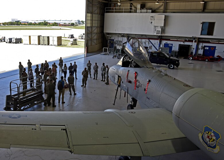 Members of the Office of the Cost Assessment and Program Evaluation listen to a briefing June 1, 2017, in the A-10 maintenance hangar at Warfield Air National Guard Base, Md. The brief was conducted by the wing commander and was the first stop of a day-long tour of the base. (U.S. Air National Guard photo by Airman Sarah M. McClanahan /Released Master Sgt. Chris Schepers)