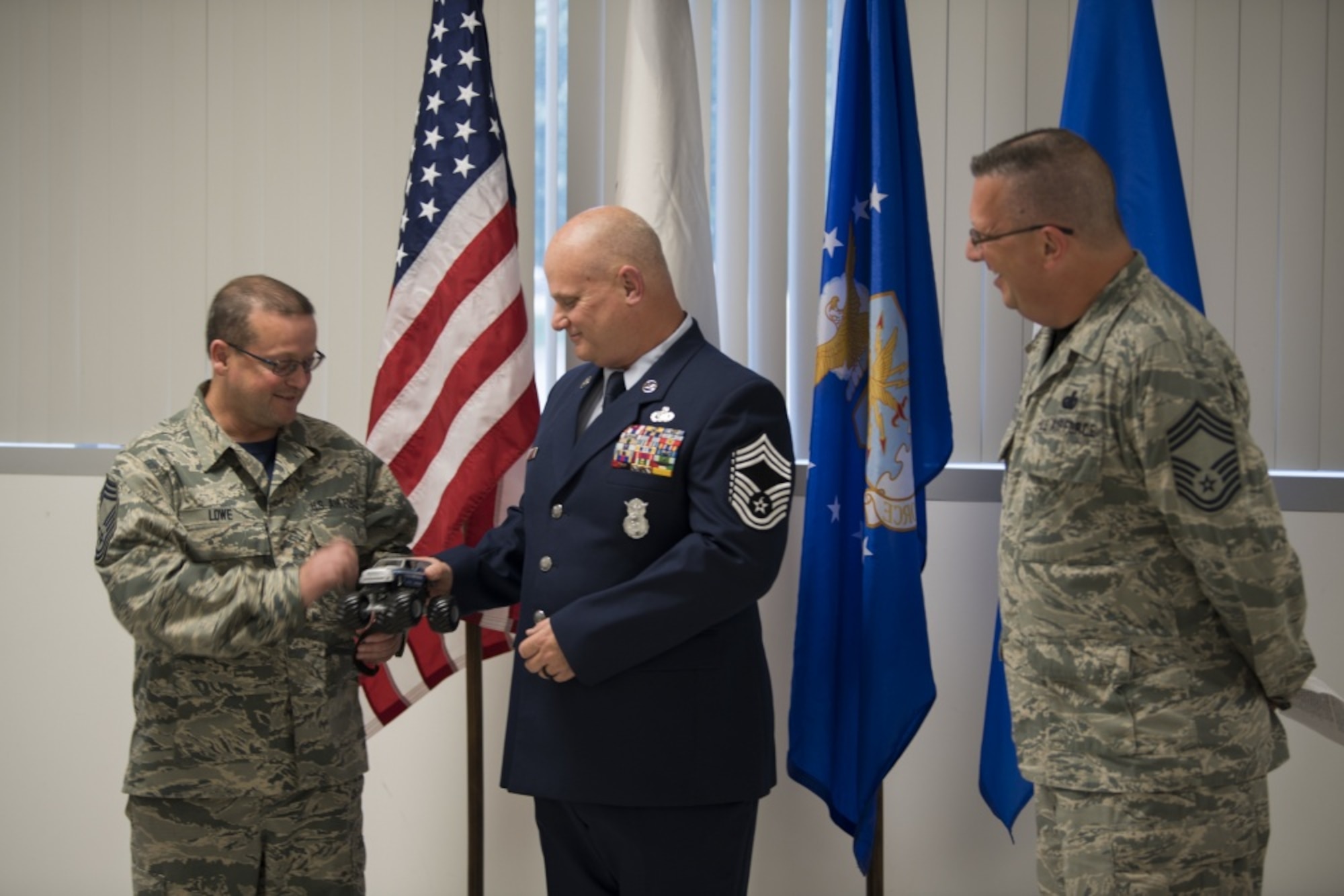 Chief Master Sgt. John Lowe passes the symbolic “Jeep Chief” truck to Chief Master Sgt. P. Wayne Hughes during Hughes’ promotion ceremony held June 3, 2017 at McLaughlin Air National Guard Base, Charleston, W.Va. The “Jeep Chief” is the newest promoted chief on base and is symbolic of a newly promoted individual in the military. The 130th Airlift Wing Chief’s Council presents this token to new Chiefs as a reminder of their role and responsibility in the position. (U.S. Air National photo by Capt. Holli Nelson) 