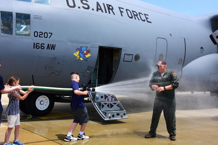 Lt. Col. Arne Kolbjornsen, pilot, 142nd Airlift Squadron is hosed down in true flying tradition by his two children. After 29 years of service and 5335.4 flying hours, family and members from the 166th Airlift Wing came out to congratulate him on his incredible career and thank him for his leadership and friendship, Delaware Air National Guard Base, New Castle, Del., 31 May 2017. (U.S. Air National Guard photo by SSgt. Andrew Horgan/released)