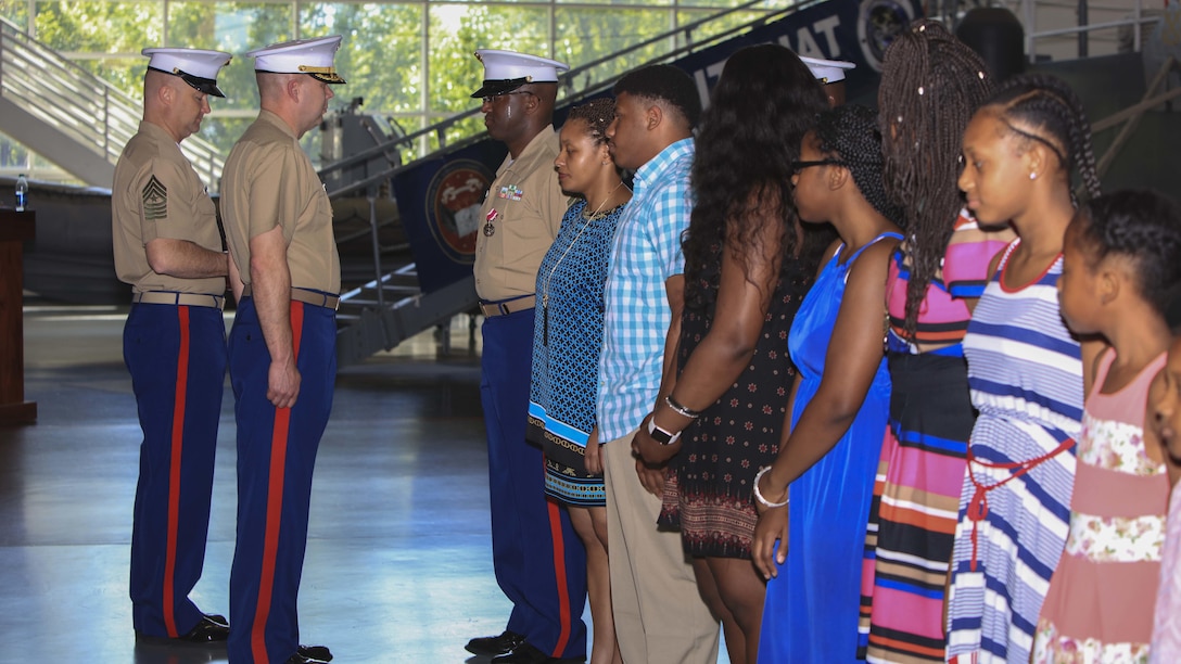 Master Sgt. David Roberts, now officially retired, and his family receive awards and certificates of appreciation from Lt. Col. Charles Winchester, the executive officer of 9th Marine Corps District, aboard Naval Station Great Lakes, Ill., June 2. Roberts, a Bronx native, served in various administrative roles during his career and retired after 23 years of honorable service.