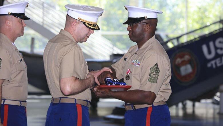 Master Sgt. David Roberts, now officially retired, and his family receive awards and certificates of appreciation from Lt. Col. Charles Winchester, the executive officer of 9th Marine Corps District, aboard Naval Station Great Lakes, Ill., June 2. Roberts, a Bronx native, served in various administrative roles during his career and retired after 23 years of honorable service.