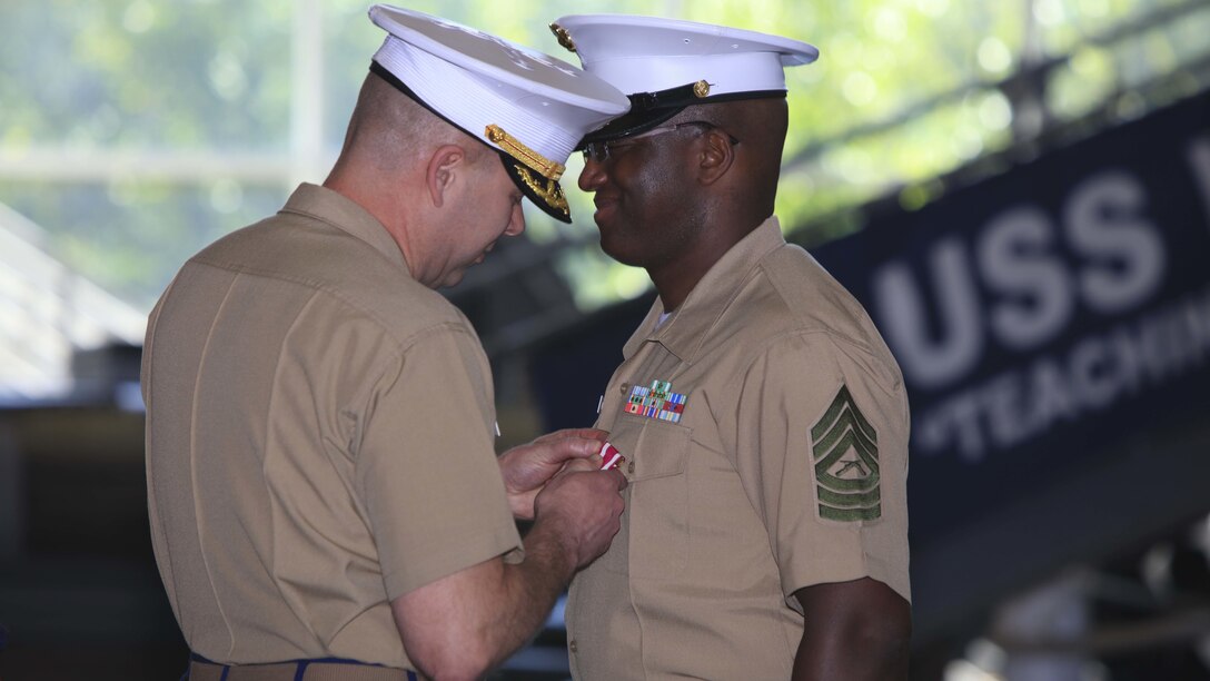 Master Sgt. David Roberts, now officially retired, and his family receive awards and certificates of appreciation from Lt. Col. Charles Winchester, the executive officer of 9th Marine Corps District, aboard Naval Station Great Lakes, Ill., June 2. Roberts, a Bronx native, served in various administrative roles during his career and retired after 23 years of honorable service.