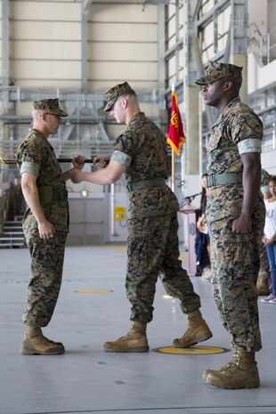 U.S. Marine Corps Lt. Col. Kevin A. Campbell, commanding officer of Headquarters and Headquarters Squadron (H&HS), commences the passing of the sword of office to Sgt. Maj. Jason Cain at Marine Corps Air Station Iwakuni, Japan, June 2, 2017. A relief and appointment ceremony was held to welcome the incoming and see off the outbound sergeant major. (U.S. Marine Corps photo by Lance Cpl. Joseph Abrego)