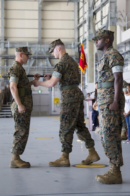 U.S. Marine Corps Lt. Col. Kevin A. Campbell, commanding officer of Headquarters and Headquarters Squadron (H&HS), commences the passing of the sword of office to Sgt. Maj. Jason Cain at Marine Corps Air Station Iwakuni, Japan, June 2, 2017. A relief and appointment ceremony was held to welcome the incoming and see off the outbound sergeant major. (U.S. Marine Corps photo by Lance Cpl. Joseph Abrego)