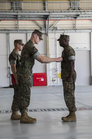 U.S. Marine Corps Lt. Col. Kevin A. Campbell, left, commanding officer of Headquarters and Headquarters Squadron (H&HS), places a meritorious service medal on Sgt. Maj. Darnell Richardson, right, outgoing H&HS sergeant major, during a relief and appointment ceremony at Marine Corps Air Station Iwakuni, Japan, June 2, 2017. The relief and appointment ceremony was held to welcome the incoming and see off the outbound sergeant major. (U.S. Marine Corps photo by Lance Cpl. Joseph Abrego)