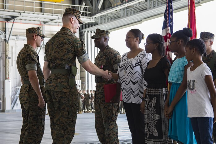 U.S. Marine Corps Lt. Col. Kevin A. Campbell, left, commanding officer of Headquarters and Headquarters Squadron (H&HS), hands an award to Renita B. Richardson, wife of outgoing H&HS sergeant major, during a relief and appointment ceremony at Marine Corps Air Station Iwakuni, Japan, June 2, 2017. The relief and appointment ceremony was held to welcome the incoming and see off the outbound sergeant major. (U.S. Marine Corps photo by Lance Cpl. Joseph Abrego)