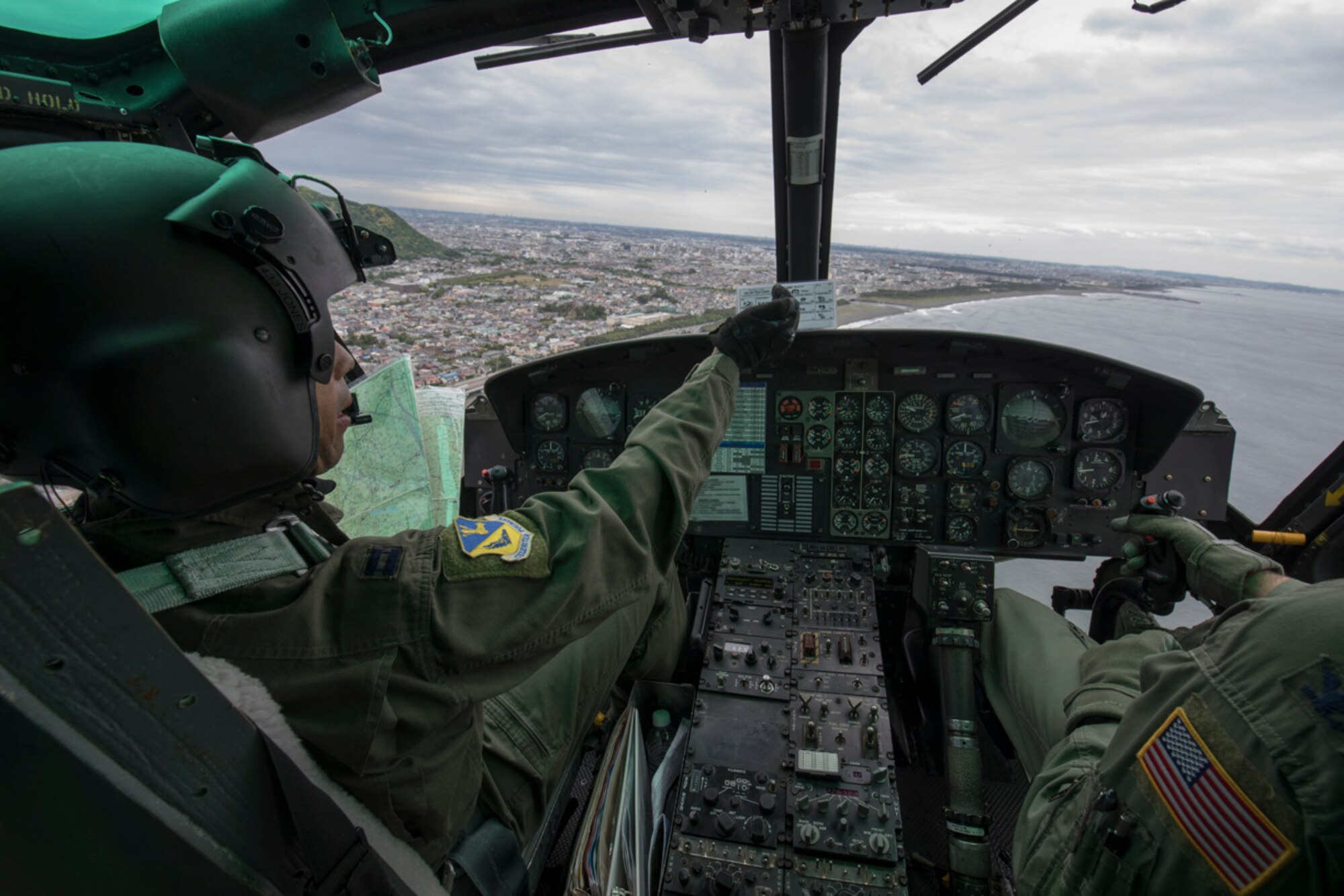 Capt. Brandon Jones, 374th Airlift Wing UH-1N pilot, points out the route to Col. Robert Dotson, right, 374th Operations Group commander, during Col. Dotson’s fini flight over the Sagami Bay, May 25, 2017.  Dotson made his final flights in a C-12 Huron and an UH-1N Iroquois during that day. (U.S. Air Force photo by Yasuo Osakabe)