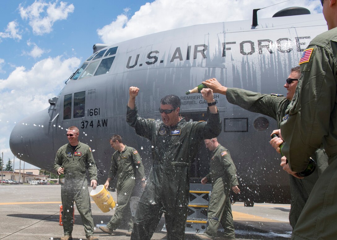 Col. Robert L. Dotson, 374th Operations commander, is doused in water to celebrate the end of his final flight, June 2, 2017, at Yokota Air Base, Japan. Fini flights follow an Air Force tradition where aircrew members are met and hosed down with water by their group comrades, families and friends. (U.S. Air Force photo by Airman 1st Class Juan Torres)