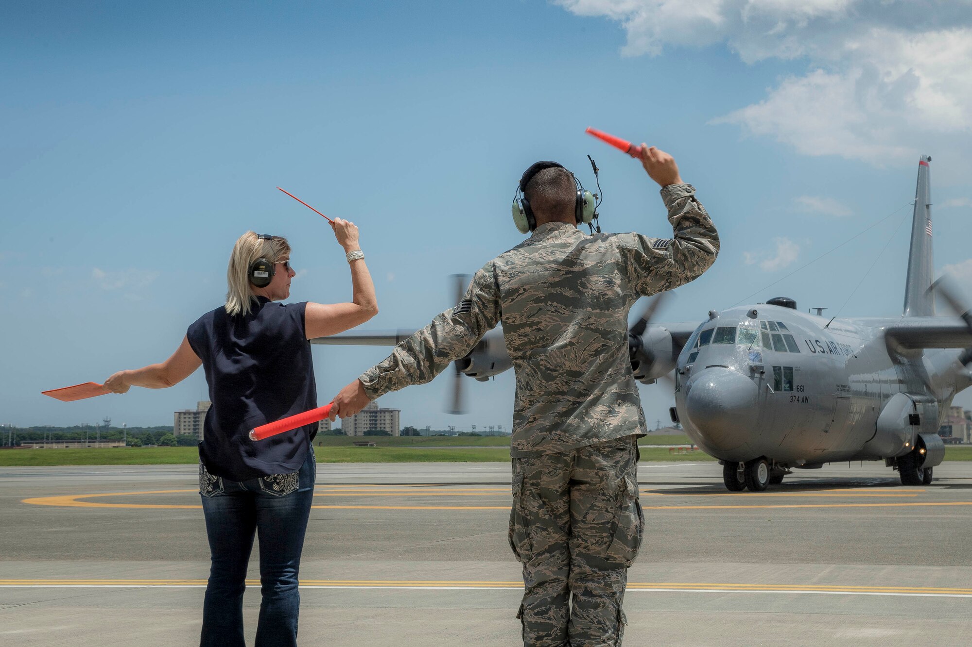 Trish Dotson marshals in C-130H Hercules after Col. Robert Dotson’s, 374th Operations Group commander, fini flight at Yokota Air Base, Japan, June 2, 2017. Dotson’s last flight, known as a “fini” flight, follows an Air Force tradition dating back to WWII where upon completion of an aircrew member’s final flight they are doused with water and congratulated by their comrades in arms and family. (U.S. Air Force photo by Airman 1st Class Donald Hudson)