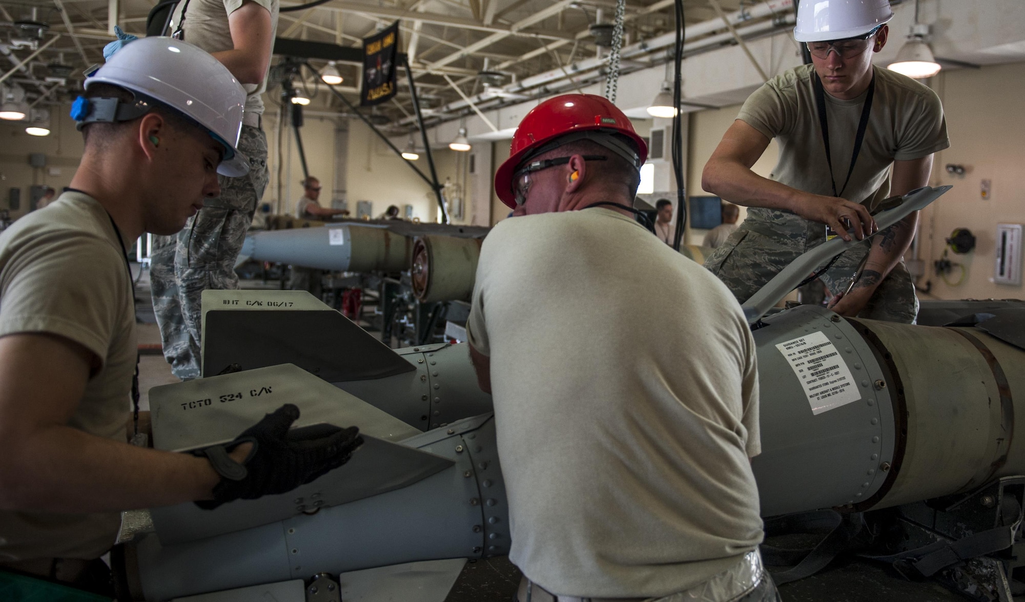 U.S. Air Force Airman 1st Class Hunter Feise, left, Staff Sgt. Shawn Monteer, center, and Senior Airman Peter Evanciew, right, 8th Maintenance Squadron conventional maintenance crew members, remove the tail of a Guided Bomb Unit 31 version 3 during the Combat Ammunition Production Exercise at Kunsan Air Base, Republic of Korea, June 5, 2017. CAPEX allowed Airmen to test their readiness, which is critical in the deterrence of aggression and defending the Republic of Korea. Approximately 350 Airmen from bases across PACAF as well as two Air National Guard units participated. (U.S. Air Force photo by Senior Airman Colville McFee/Released)