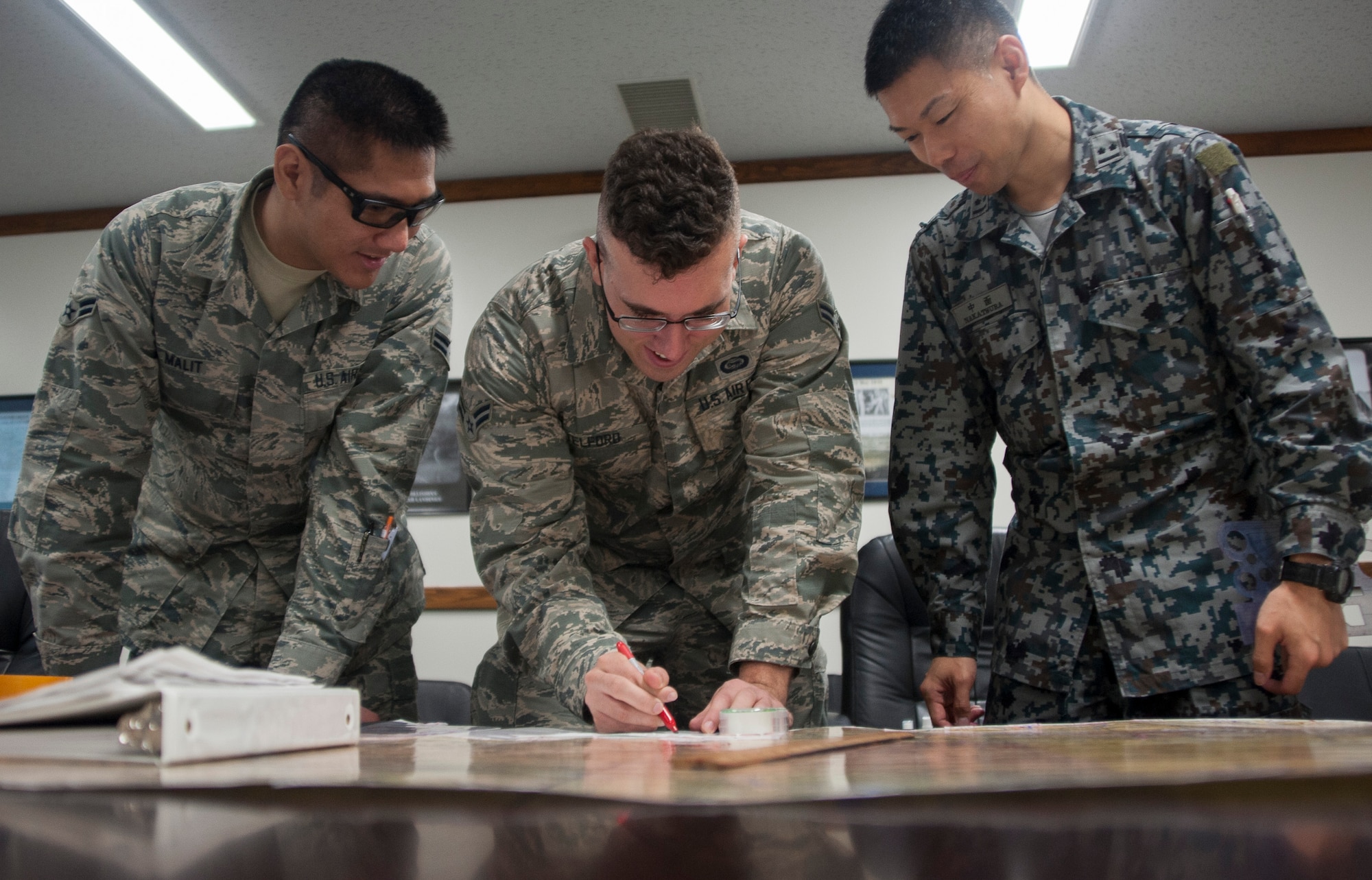 The 35th Operations Support Squadron intelligence analysts and Japan Air Self-Defense Force counterparts plot coordinates on a map in preparation for Red Flag-Alaska 17-2, at Misawa Air Base, Japan, May 26, 2017. RF-A is a field training exercise in a simulated combat environment that ensures the highest level of readiness within the Indo-Asia-Pacific region. (U.S. Air Force photo by Staff Sgt. Melanie A. Hutto)