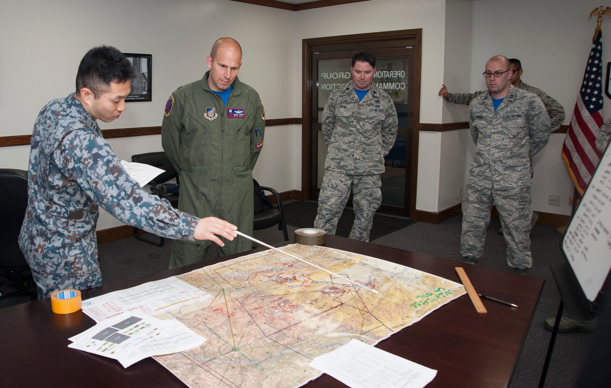 A Japan Air Self-Defense Force member from Yokota Air Base, Japan, briefs Lt. Col. Kevin Lord, the 35th Operations Support Squadron commander, as part of the mission planning cell at Misawa Air Base, Japan, May 26, 2017. Over the course of a week the 35th OSS intelligence analysts dedicated over 50 hours familiarizing four Japan Air Self-Defense Forces counterparts on mission-set requirements for RED FLAG-Alaska, 17-2. This exercise is one of several that the U.S. and Japan participate in, ensuring the “fight tonight” mentality is strengthened. (U.S. Air Force photo by Staff Sgt. Melanie A. Hutto)