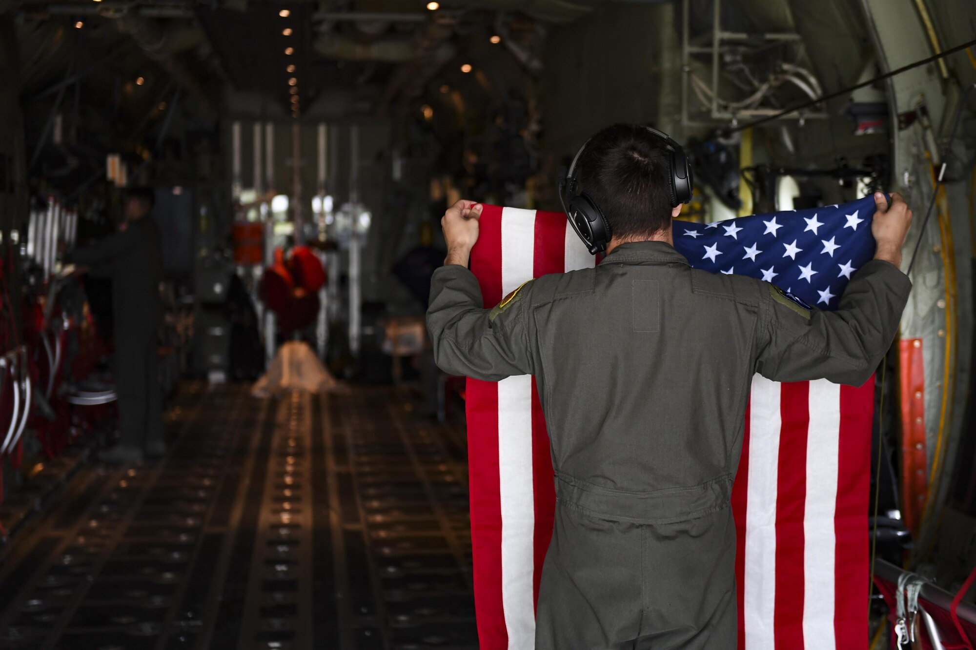 U.S. Air Force Senior Airman Matthew Gee, 37th Airlift Squadron aircraft loadmaster, hangs the American flag inside a C-130J Super Hercules assigned to Ramstein Air Base, Germany, before taking off at Cherbourg-Maupertus Airport, France, May 30, 2017. This event commemorates the 73rd anniversary of D-Day, the largest multi-national amphibious landing and operational military airdrop in history, and highlights the U.S.' steadfast commitment to European allies and partners. Overall, approximately 400 U.S. service members from units in Europe and the U.S. are participating in ceremonial D-Day 73 events from May 31-June 7, 2017. (U.S. Air Force photo by Senior Airman Devin Boyer)