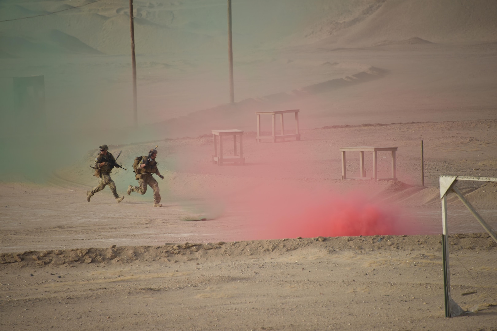 Two Air Force explosive ordnance disposal technicians use smoke grenades for cover as they run across an open area during a joint service EOD field training exercise at an undisclosed location in Southwest Asia, May 25, 2017. EOD teams from each of the four service branches, deployed to five different countries across the AOR, gathered for joint service EOD training, which allowed for the exchange of tactics, techniques and procedures between service branches. (U.S. Air Force photo/Tech. Sgt. Jonathan Hehnly)