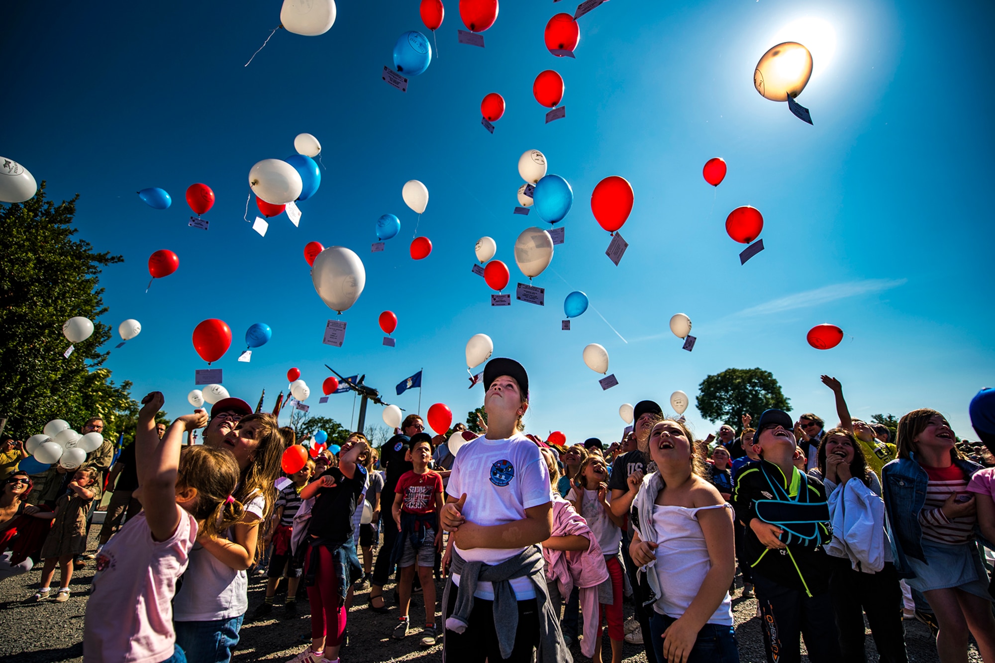 French children release balloons into the air during a D-Day remembrance ceremony at the United States Army Air Forces Transport Memorial in Picauville, France, June 1, 2017. Each balloon has a placard tied to it with the name of a fallen service member who gave their life for the liberation of France. This event commemorates the 73rd anniversary of D-Day, the largest multinational amphibious landing and operational military airdrop in history, and highlights the U.S.' steadfast commitment to European allies and partners. Overall, approximately 400 U.S. service members from units in Europe and the U.S. are participating in ceremonial D-Day 73 events from May 31-June 7, 2017. (U.S. Air Force photo by Senior Airman Devin Boyer)