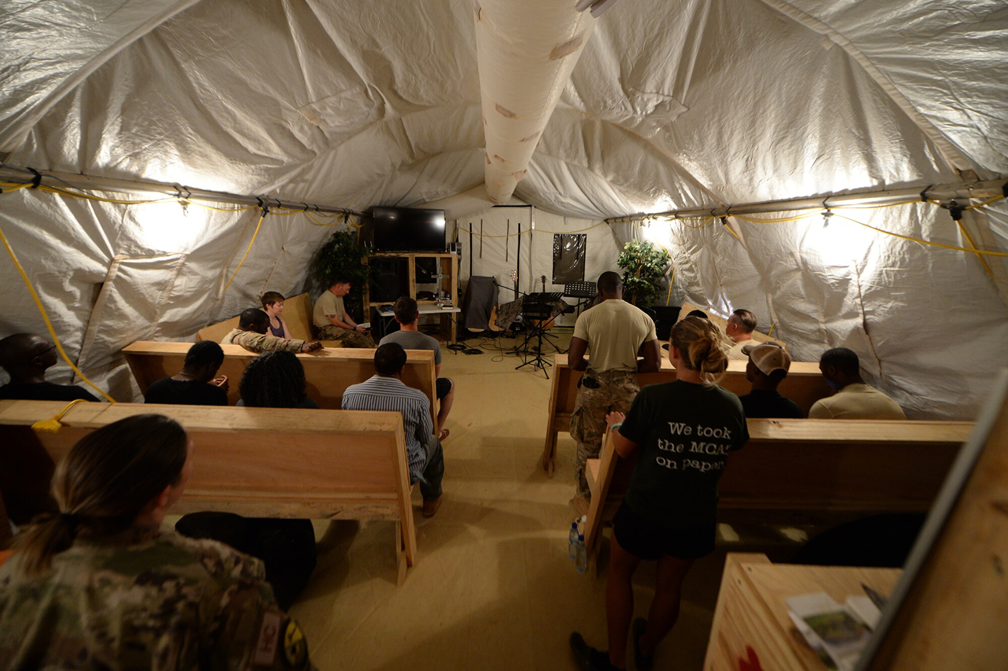 Airmen deployed to the 724th Expeditionary Air Base Squadron listen to music and reflect during an opening to a chapel service at Nigerien Air Base 201, Niger, May 14, 2017. Chapel services and other religious activities are held at the squadron’s Airmen Resiliency Center which allows Airmen to maintain their religious roots while deployed. (U.S. Air Force photo by Senior Airman Jimmie D. Pike)