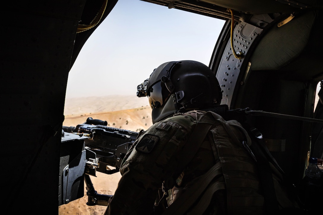 A soldier looks out from a UH-60 Black Hawk helicopter scanning the terrain below during a flight near Kunduz, Afghanistan, May 31, 2017. The soldier is a crew chief is assigned to the 7th Infantry Division’s 16th Combat Aviation Brigade, Task Force Griffin. Army photo by Capt. Brian Harris 