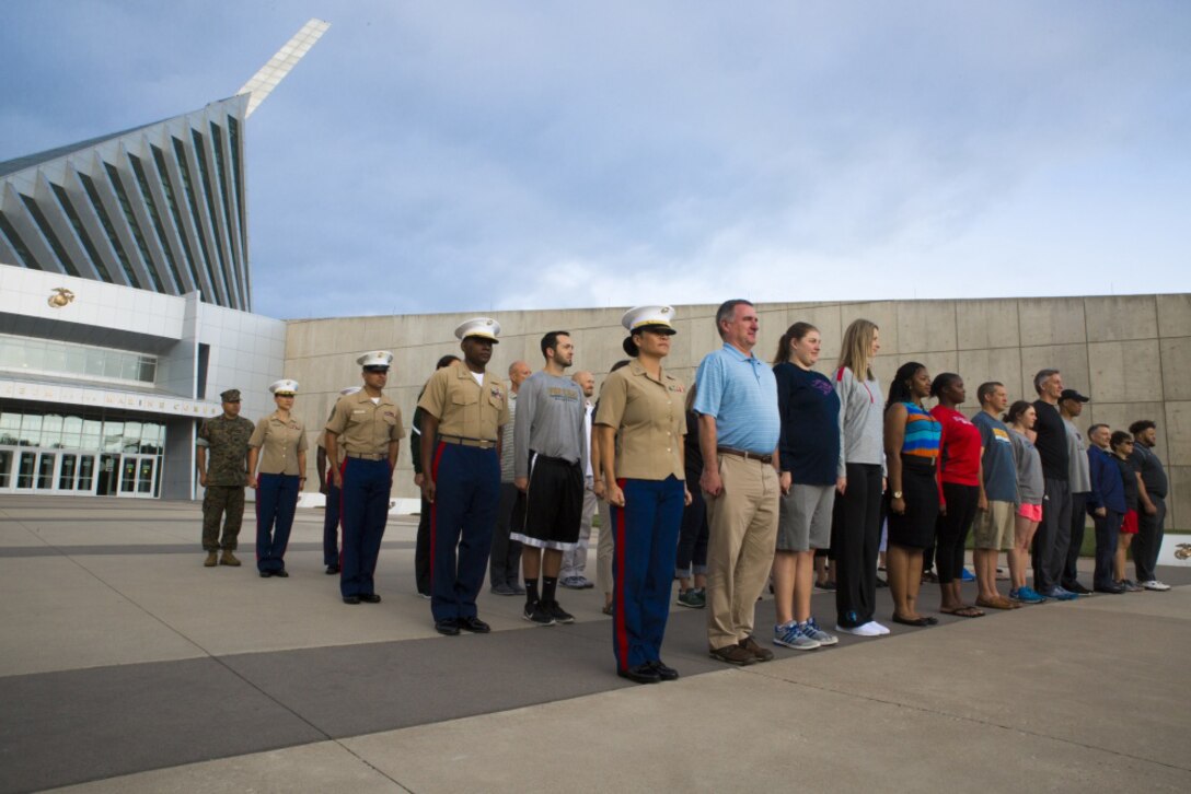 Marines and coaches stand at attention for a promotion ceremony during their visit to the National Museum of the Marine Corps as part of the 2017 Coaches Workshop, in Dumfries, Va., May 20. Thirty-five coaches travelled from across the U.S. to the Quantico area to learn about the Marine Corps' officer programs, how it vets candidates for Officer Candidates School, trains officers and develops its officer corps. The coaches received certificates for their attendance at the NMMC, which serves as a small token of appreciation for the coaches taking time out of their schedules to come aboard MCB Quantico to learn about the Corps.