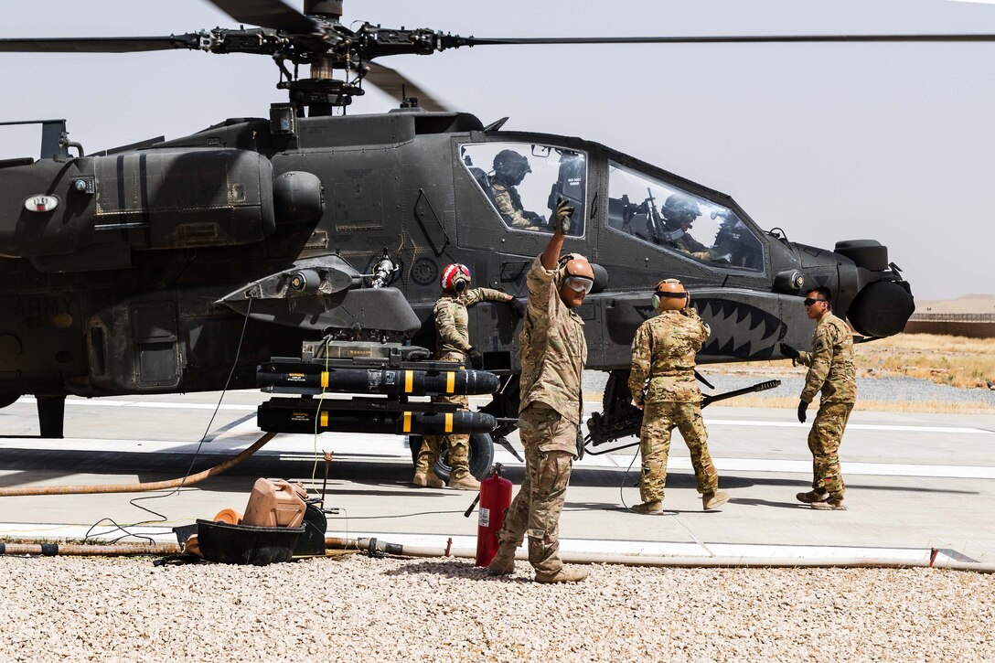 A soldier gives the signal to start refueling an AH-64E Apache helicopter in Kunduz, Afghanistan, May 31, 2017. Army photo by Capt. Brian Harris
