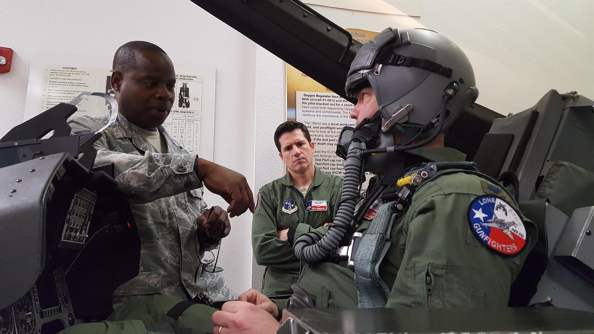 Master Sgt. Tracy Potts (left), 149th Fighter Wing NCO in charge of air crew flight equipment, instructs two F-16 Fighting Falcon pilots on a mock fighter jet's emergency egress system. Airmen like Potts are responsible for maintaining ejection equipment that must function perfectly to save a pilot's life.