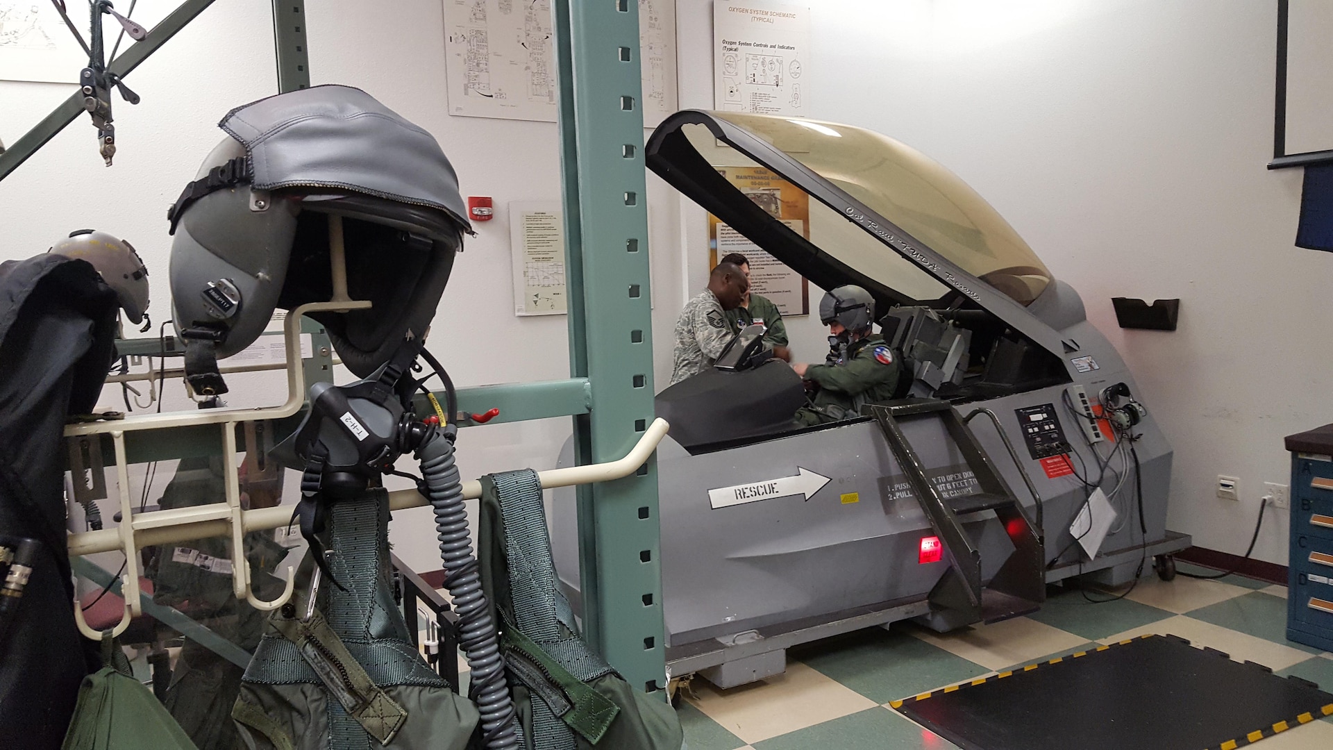 Master Sgt. Tracy Potts (left), 149th Fighter Wing NCO in charge of air crew flight equipment, instructs two F-16 pilots on a mock fighter jet's emergency egress system. Airmen like Potts are responsible for maintaining ejection equipment that must function perfectly to save a pilot's life. 