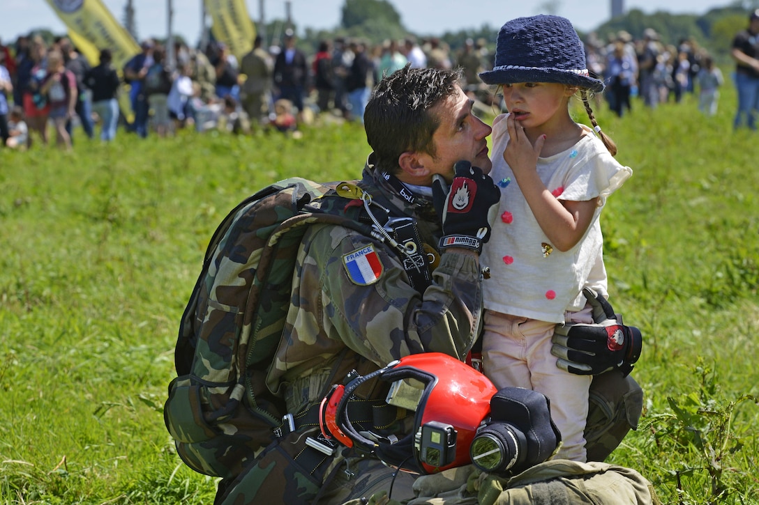 A French paratrooper greets his daughter after participating in an airborne operation commemorating D-Day in Sainte-Mere-Eglise, France, June 4, 2017. Air Force photo by Airman 1st Class Alexis C. Schultz